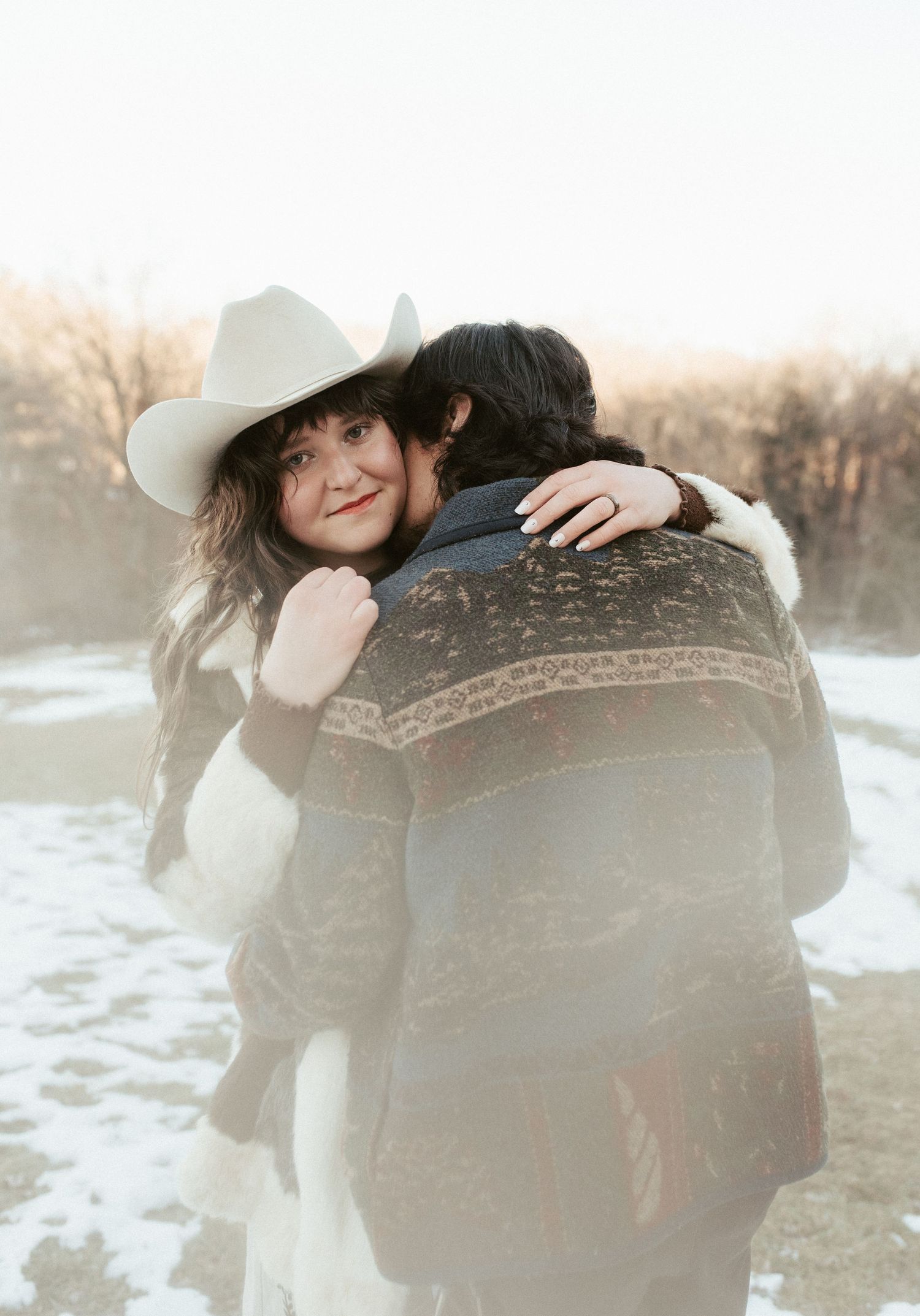 A romantic winter couple photoshoot series featuring a couple embracing in a snowy outdoor setting with soft lighting. Appleton, Green Bay &