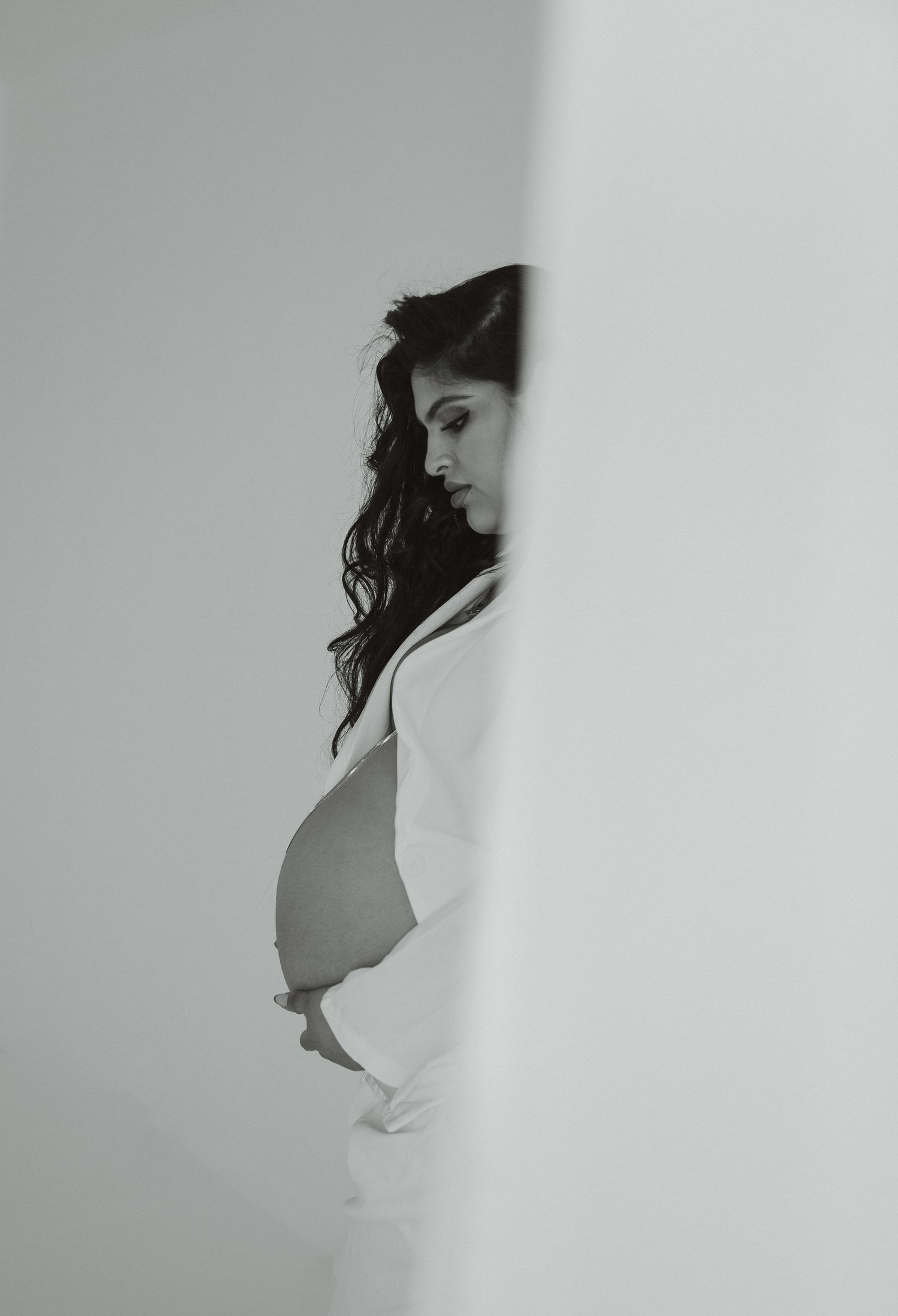 Artistic black and white maternity photos showing silhouette against white background.