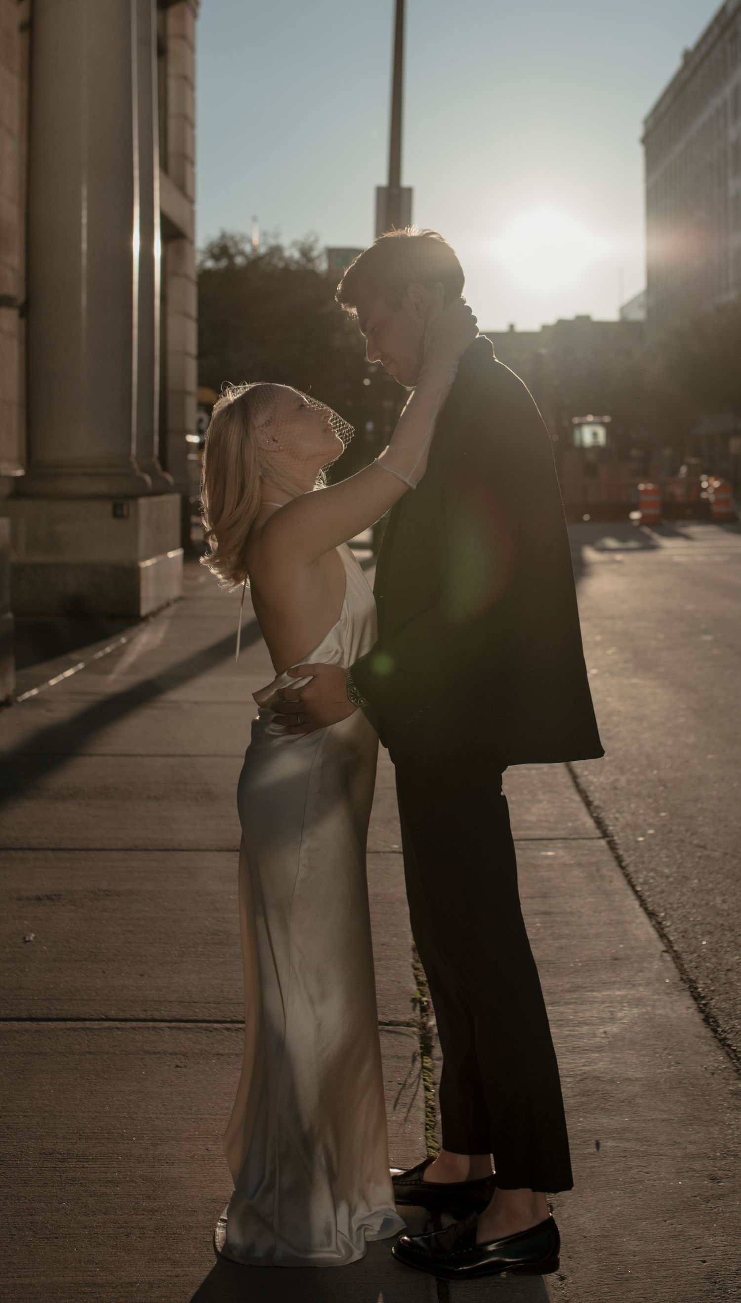 A couple dancing together at sunset in silhouette with romantic lens flare and backlighting.