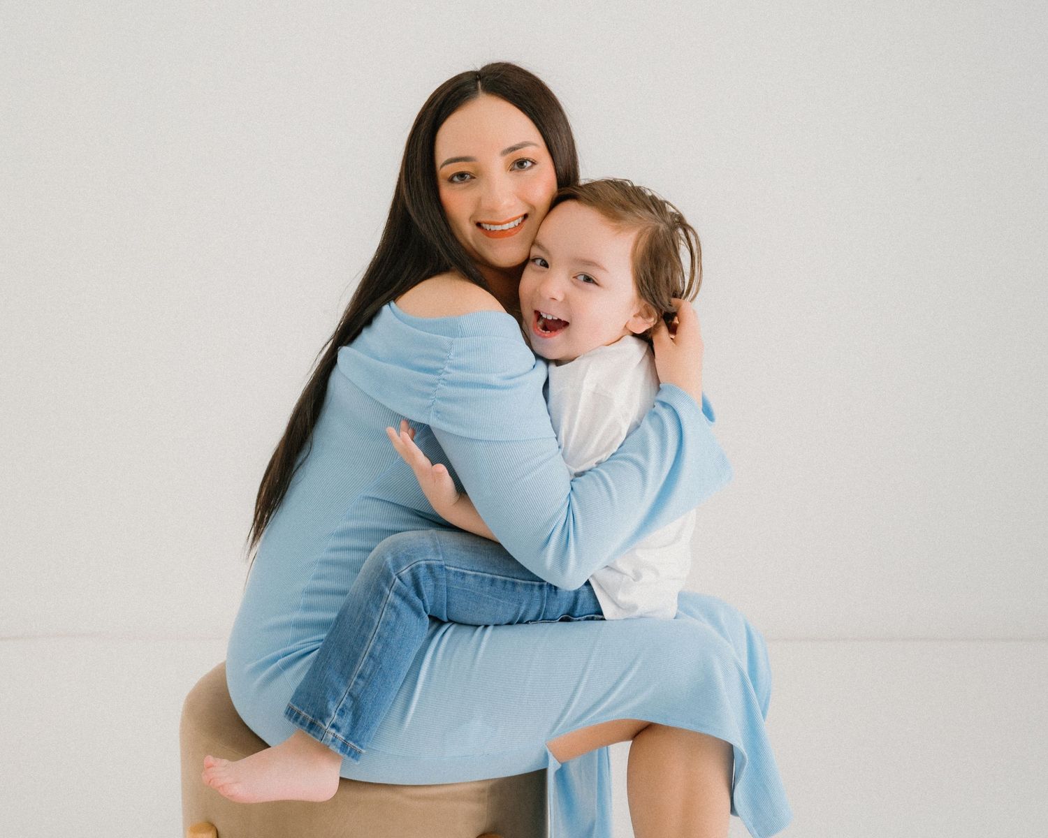 Heartwarming studio portraits capturing loving embraces between parent and child.