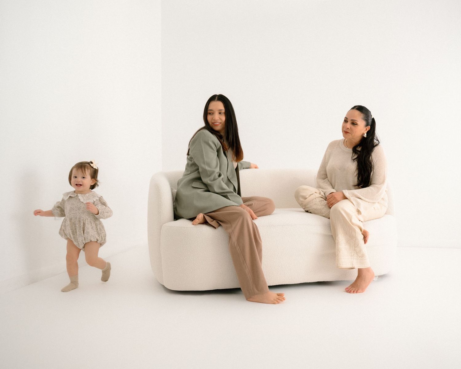 Candid family moments captured against white backdrop with modern furniture.