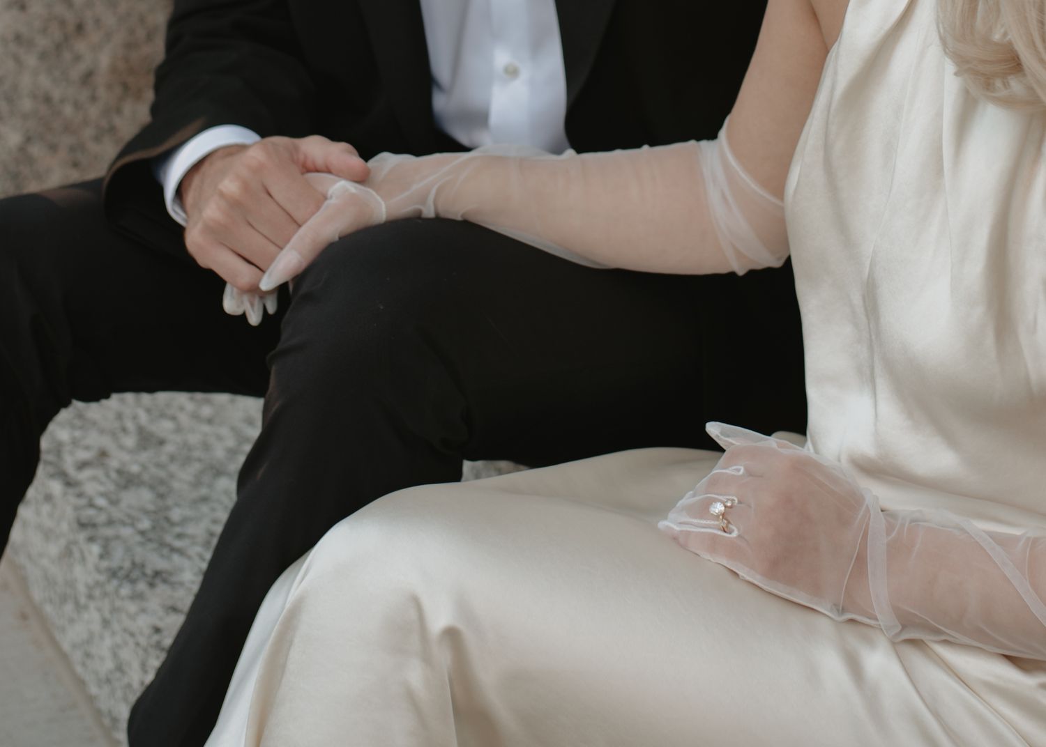 Intimate wedding moments captured against a neutral stone wall background.