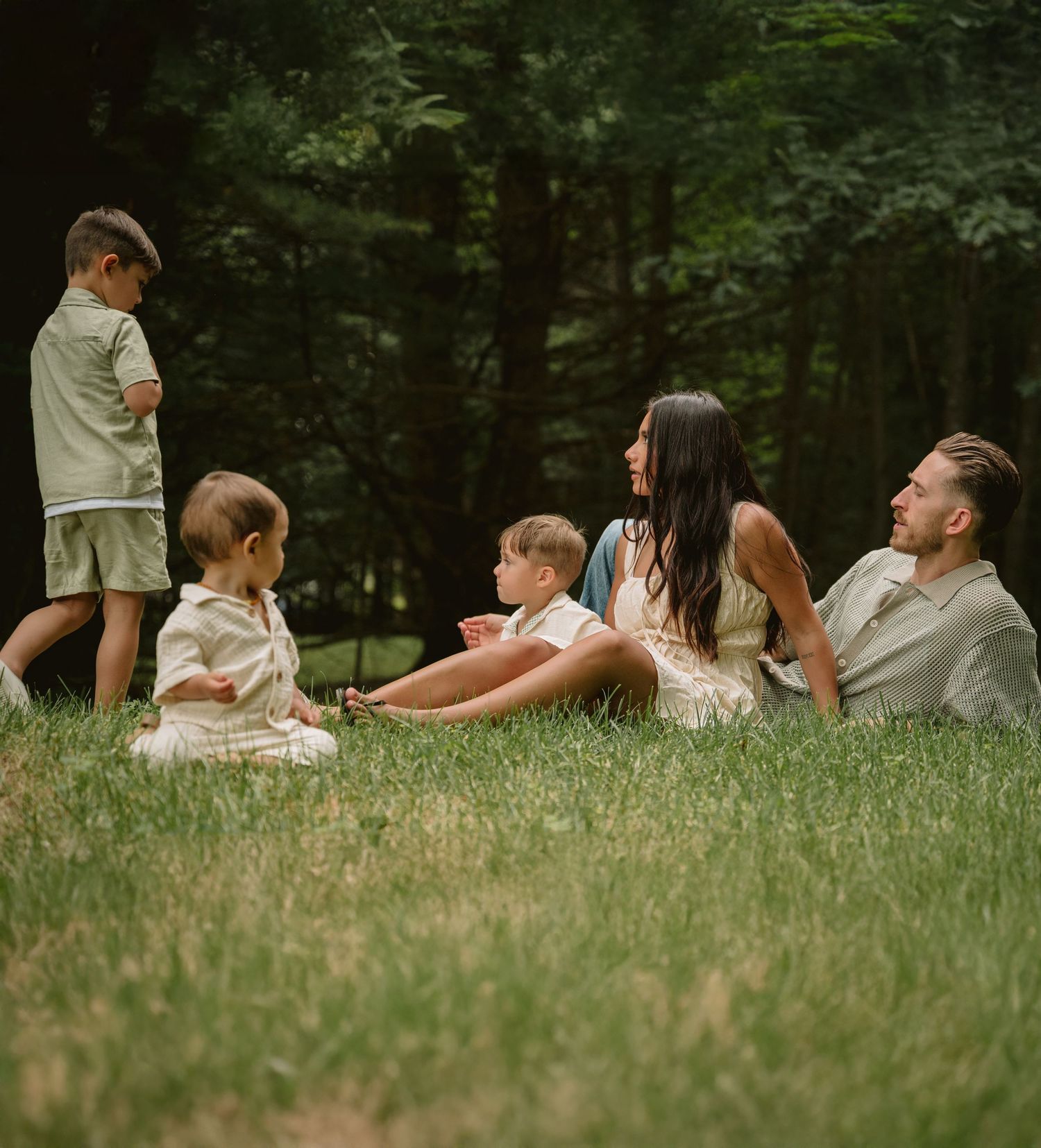 Casual family moment captured in a wooded setting during summer.