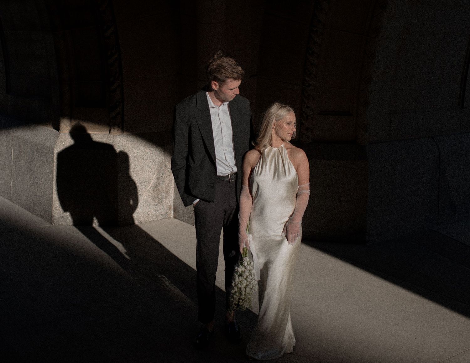 Dramatic light and shadow play in architectural wedding photography.