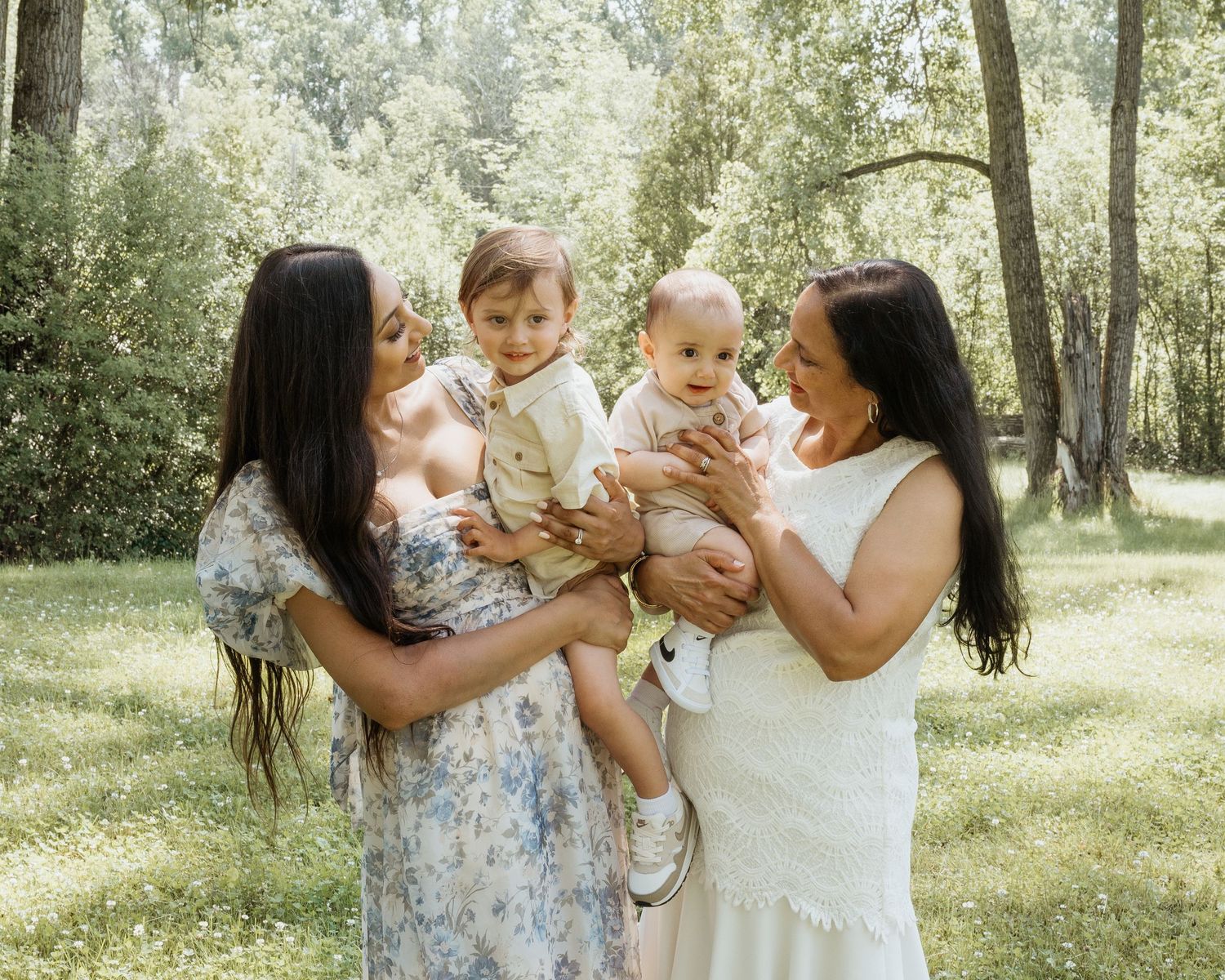 A family shares playful moments together in a sunny wooded setting.