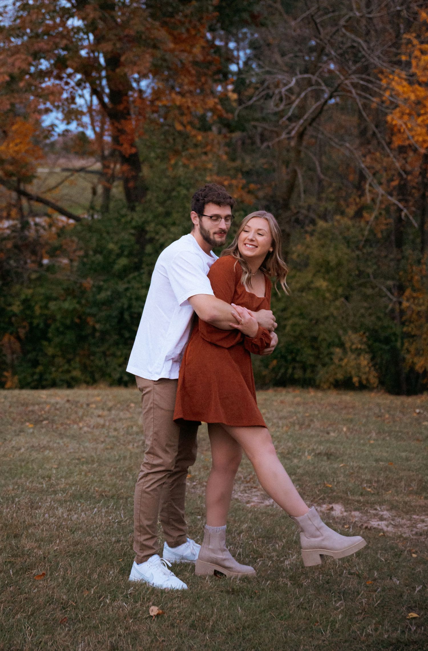 Playful dance moves captured in autumn setting with rustic brown and white outfits. Appleton, Green Bay & Kaukauna