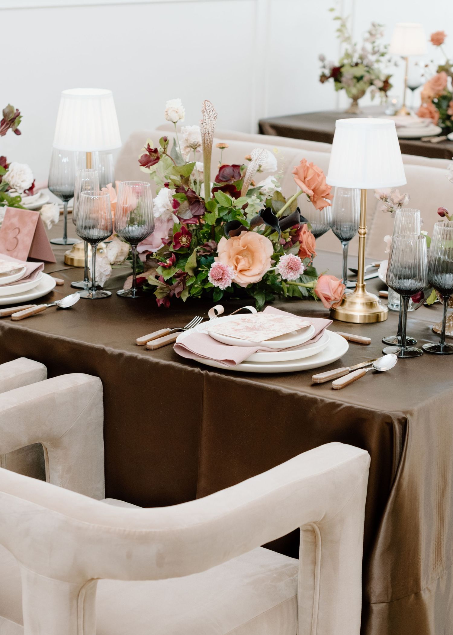 Elegant table setting with brown tablecloth, pink florals, and white table lamps at the Studio at Vic Park YYC Calgary Wedding Photographer