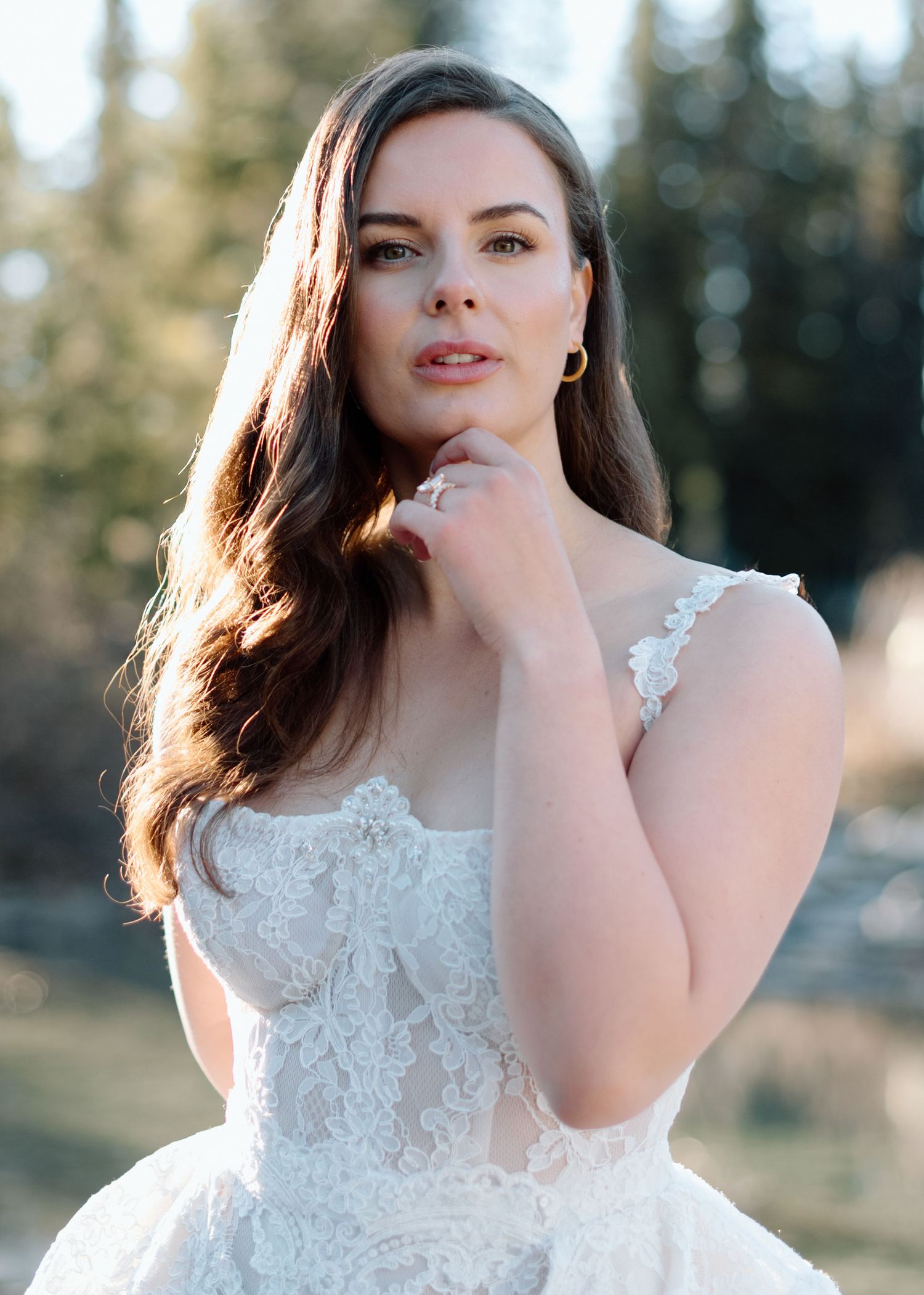 Elegant bridal portrait featuring detailed lace bodice and long dark hair at Lake Louise. Calgary and Banff Wedding Photographer
