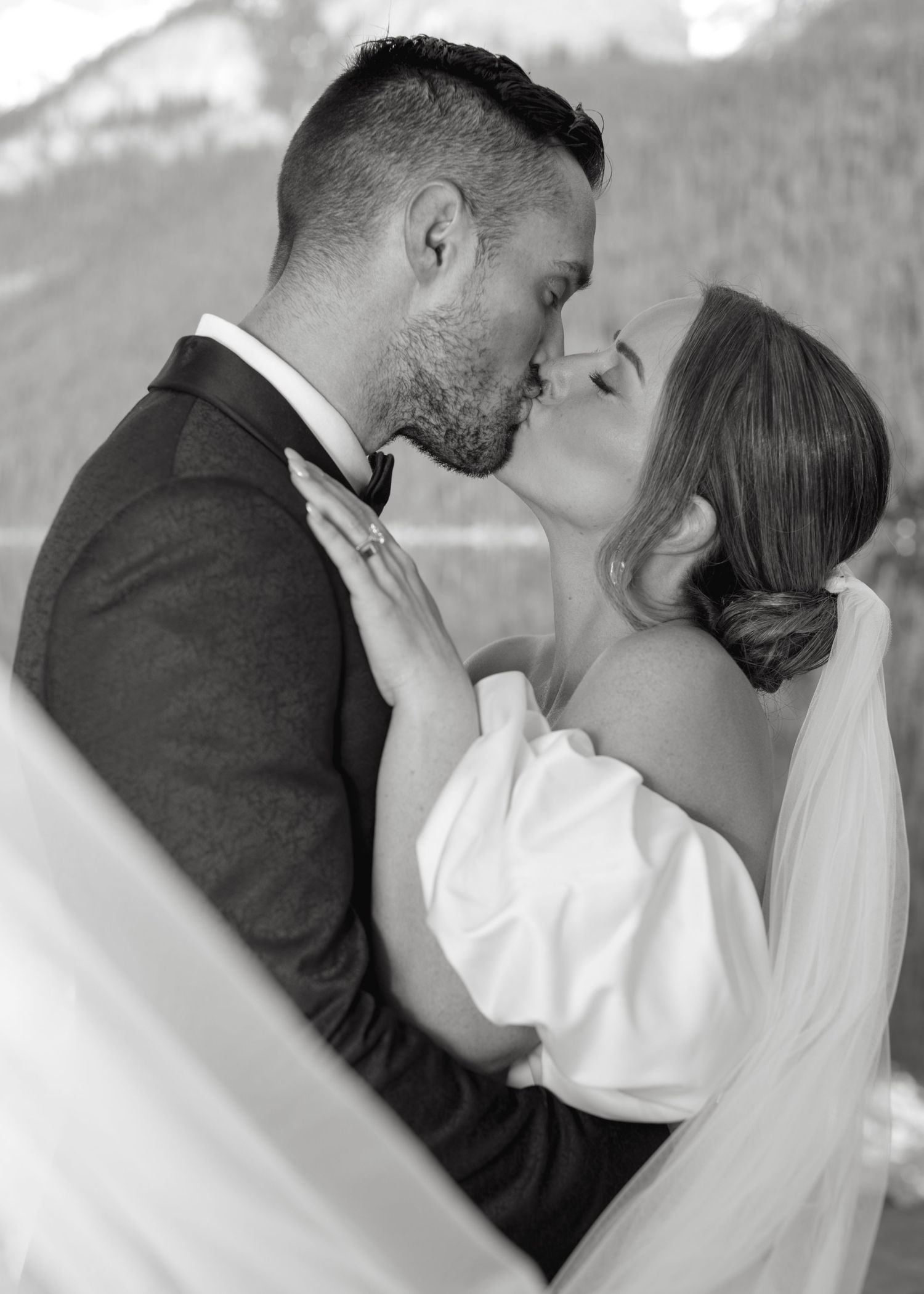 Five sequential black and white photos of newlyweds sharing intimate kisses in wedding attire.