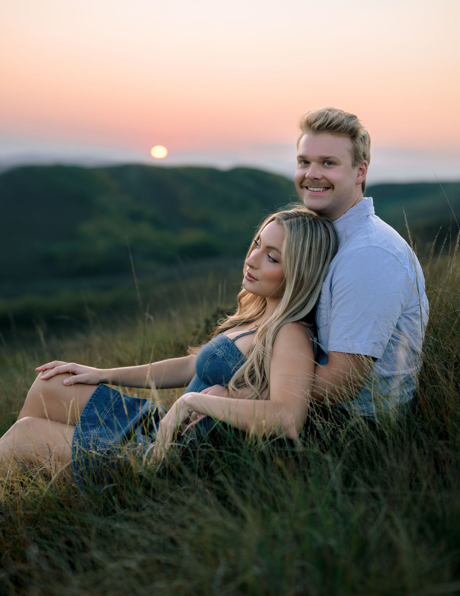 A couple relaxes together in tall grassy field during sunset as a series of romantic moments unfold in sequence.