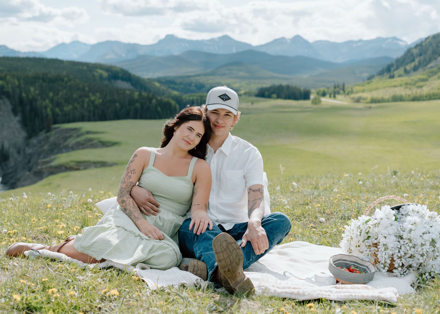 Peaceful mountain meadow picnic scene with rolling hills and distant peaks in Calgary, Alberta Calgary Lifestyle and Engagement Photographer
