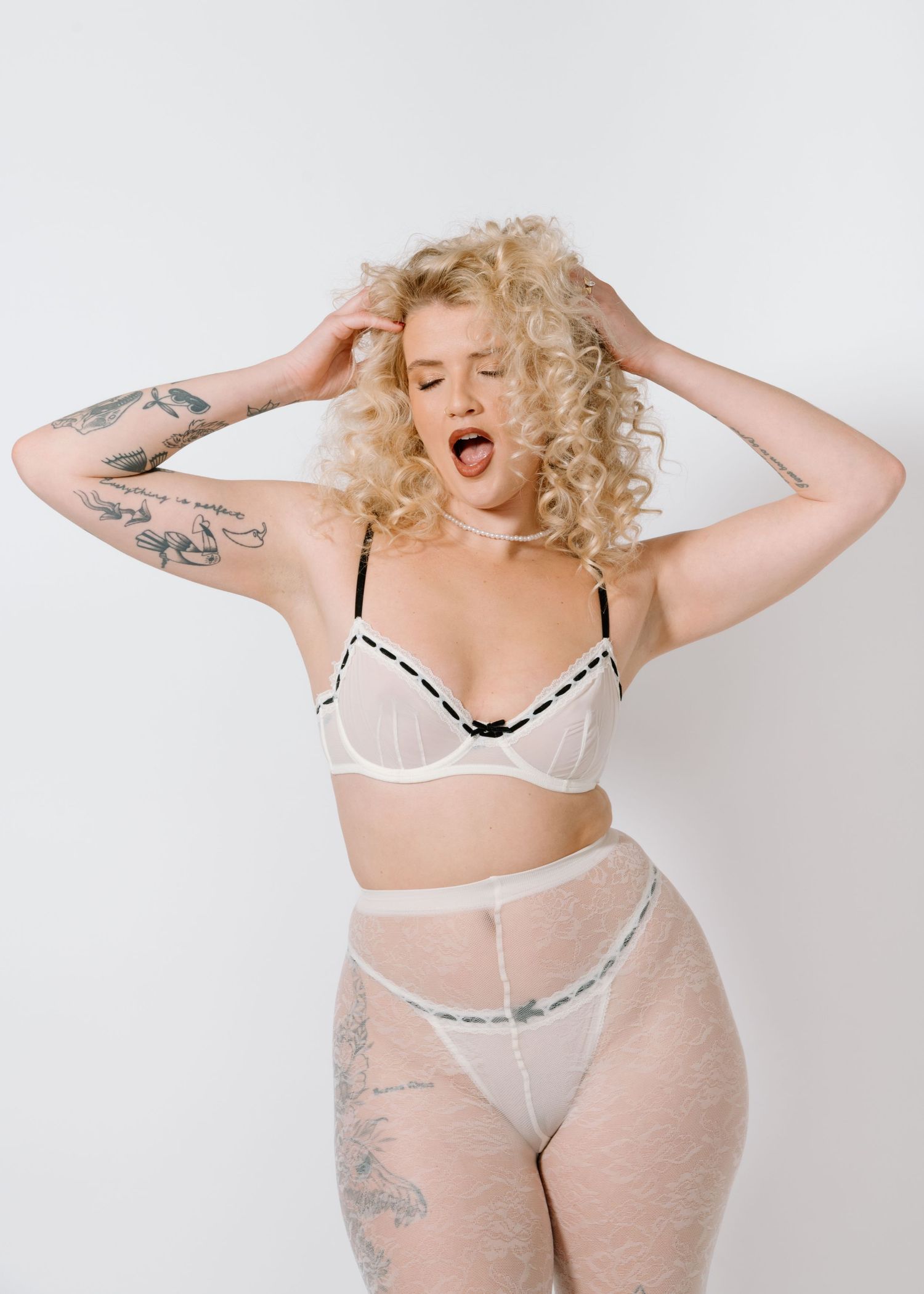 Artistic boudoir portrait featuring tattoos and sheer white lingerie set. Calgary Alberta Bridal Boudoir Photographer.