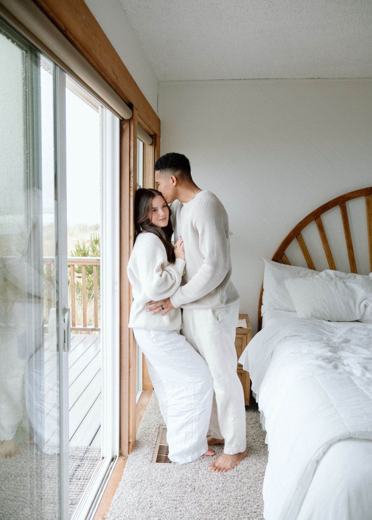A couple in white outfits shares intimate moments by a bright window in a bedroom sequence of photos.