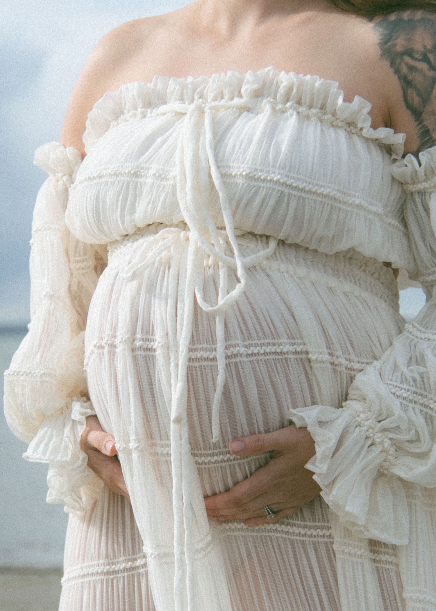 Close-up detail of white ruffled maternity dress with delicate pleating and lace texture. Calgary Alberta Maternity Photographer.