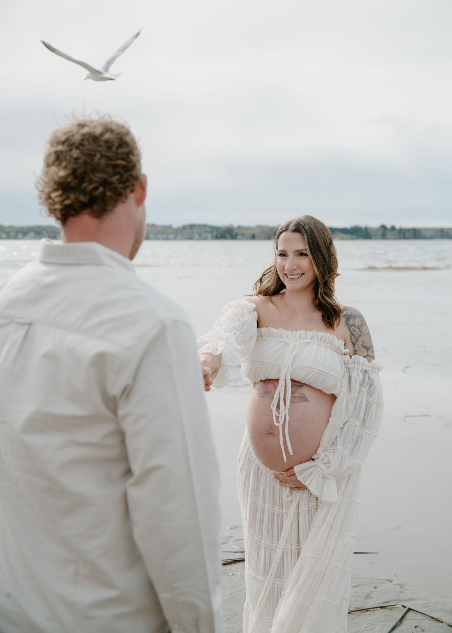 A romantic coastal photography session featuring soft whites and natural beach tones. Calgary Alberta Maternity Photographer.