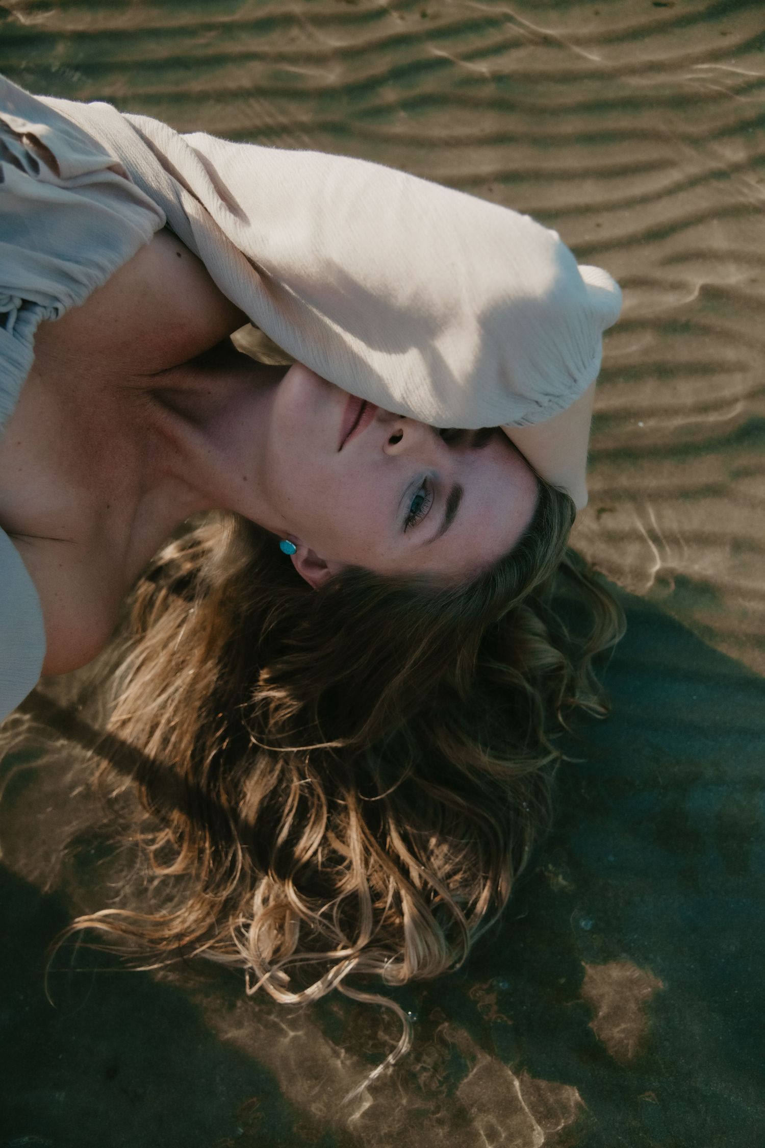 Artistic portrait shot lying down with soft lighting and dreamy atmosphere. Calgary Alberta Branding Photographer.