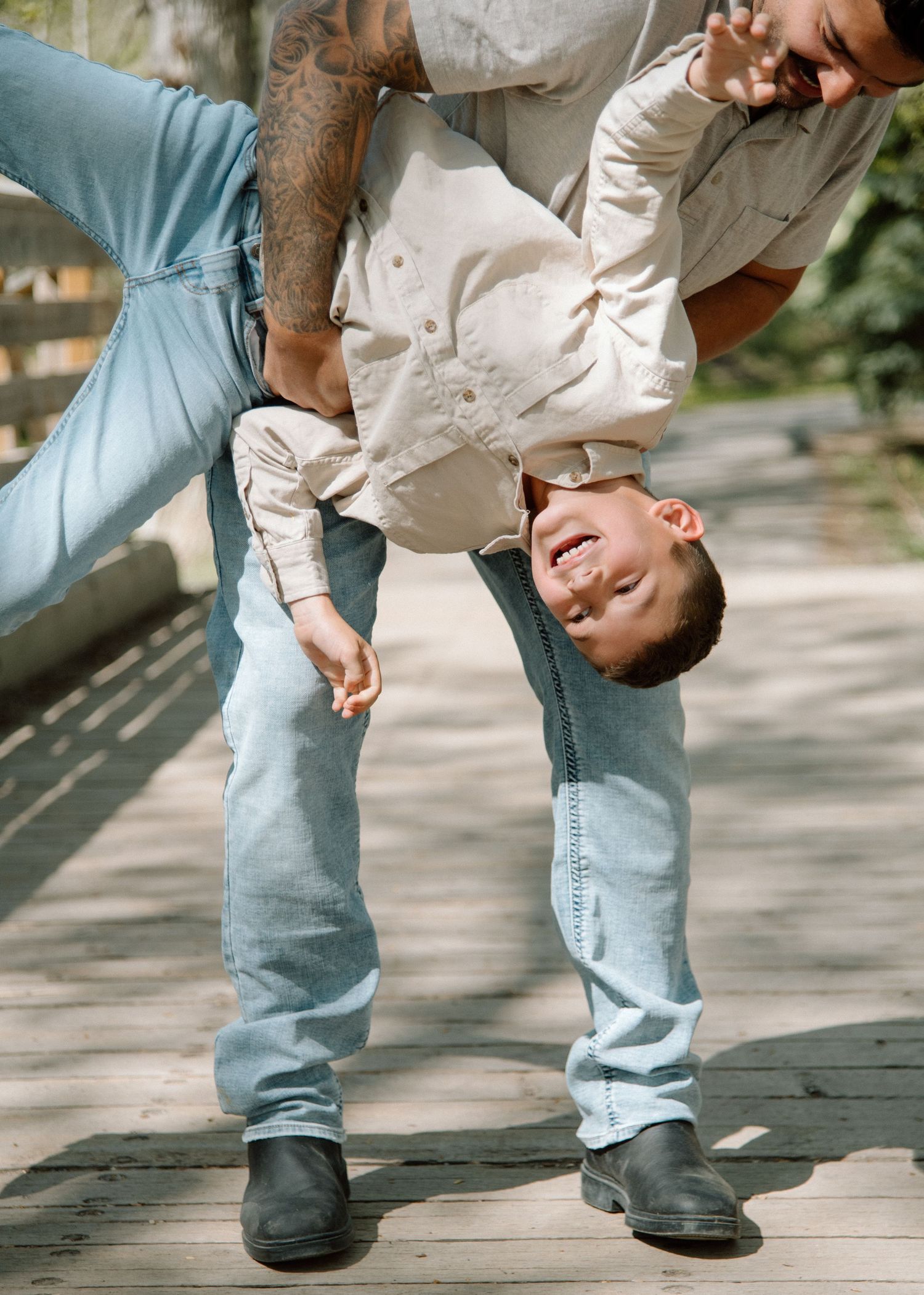 Playful dance moves captured in casual denim and white attire on a sunny patio. Calgary Alberta Family Photographer.