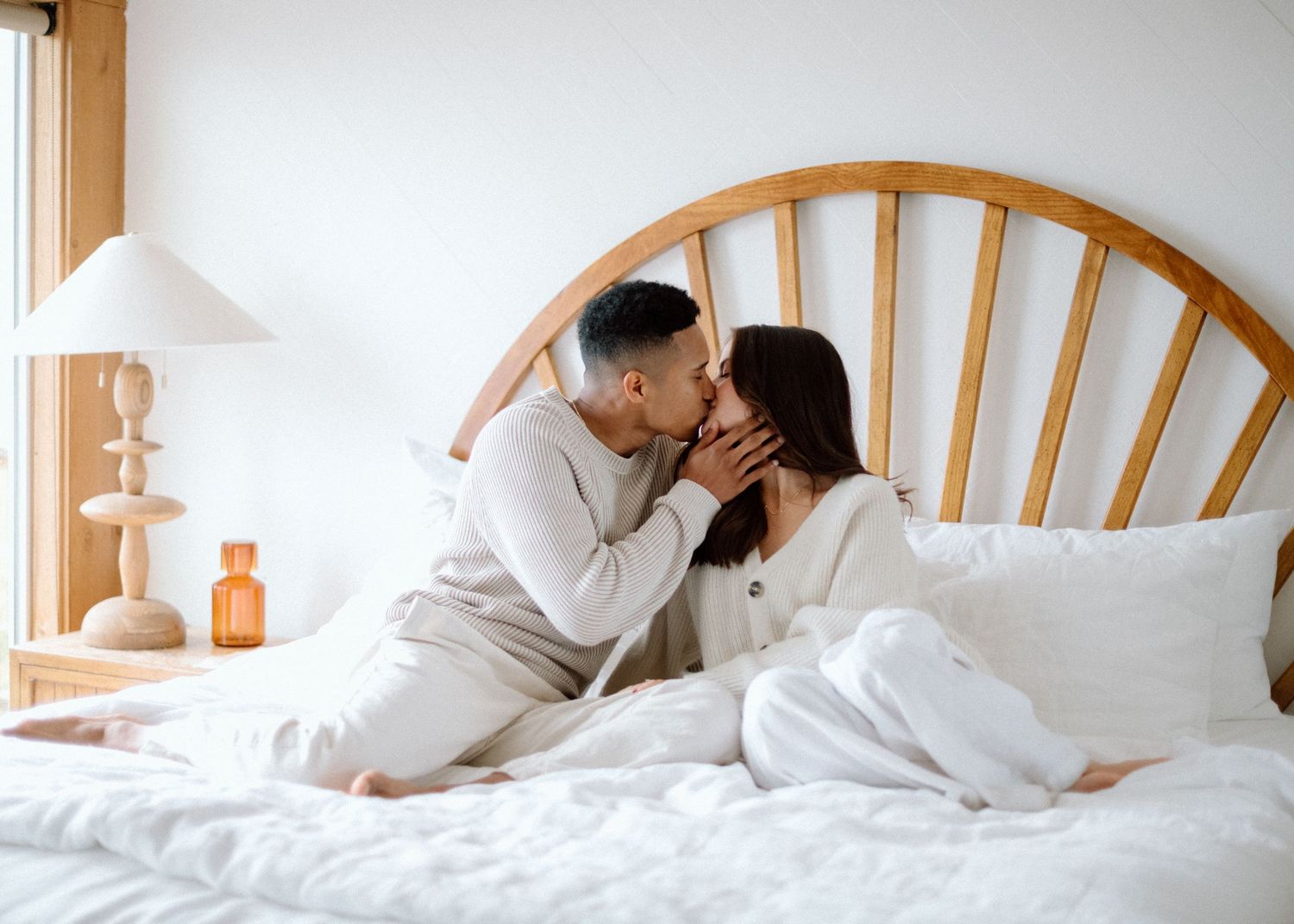 A series of photos showing someone stretching and lounging comfortably in a white bed with wooden headboard.