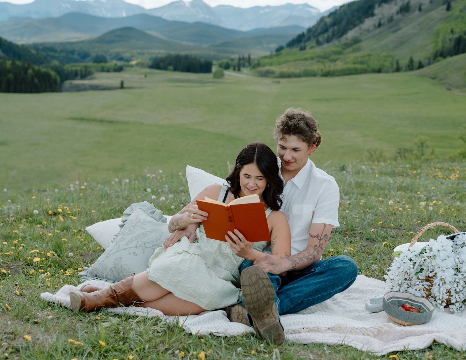 Reading books together during a mountain meadow picnic with scenic valley views in Calgary, Alberta Calgary Lifestyle and Engagement
