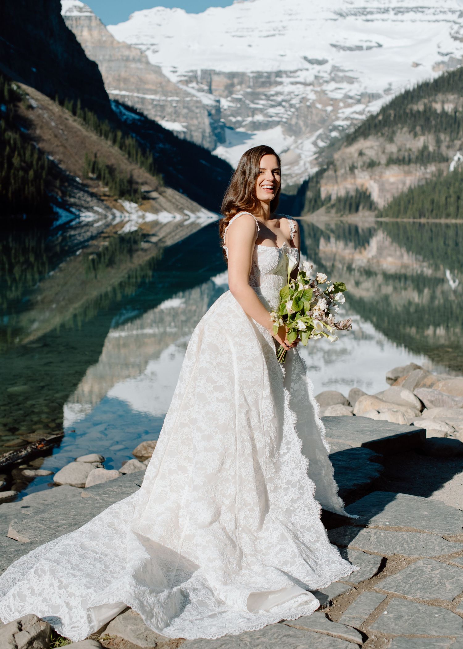 Scenic mountain lake wedding photo with snow-capped peaks and crystal clear reflections in background Banff and Calgary Wedding Photograph