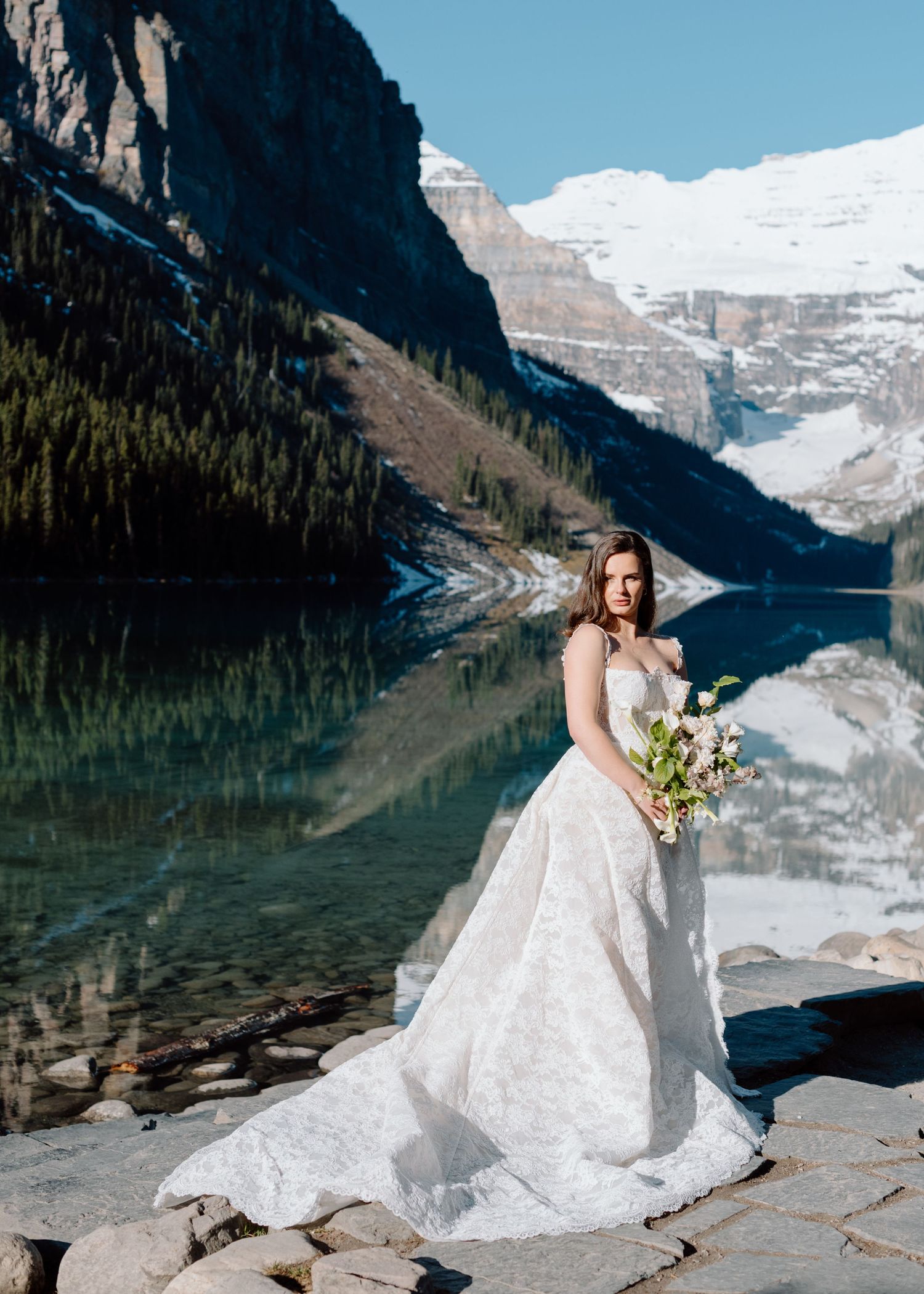 Wedding photography at Lake Louise showing dramatic mountain scenery and reflective water. Calgary and Banff Wedding Photographer