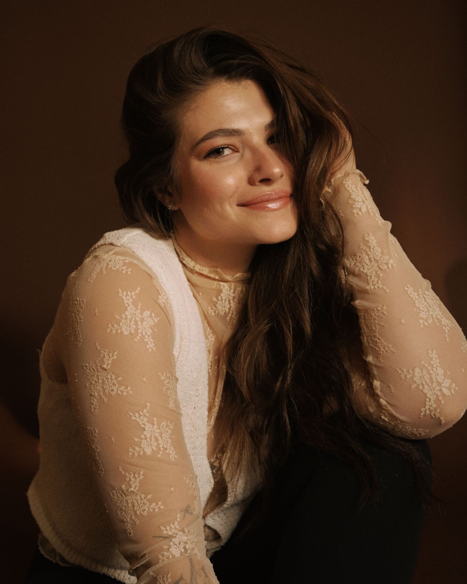 Warm-toned portrait of woman in sheer lace top with flowing hair.
Calgary Wedding Photographer