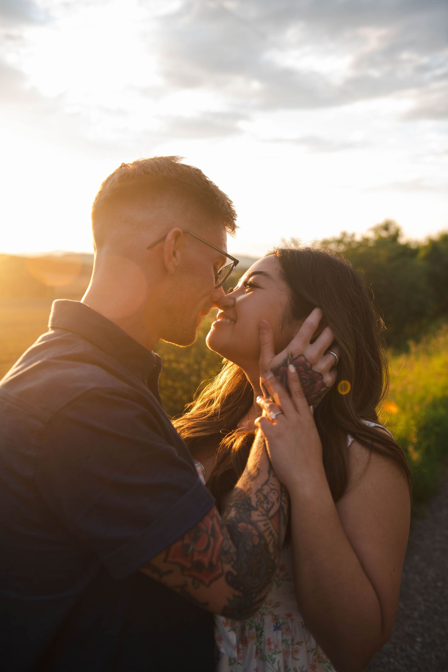 Romantic couple sharing intimate moments in a sunlit field during golden hour sunset in Calgary. Calgary Lifestyle and Engagement.