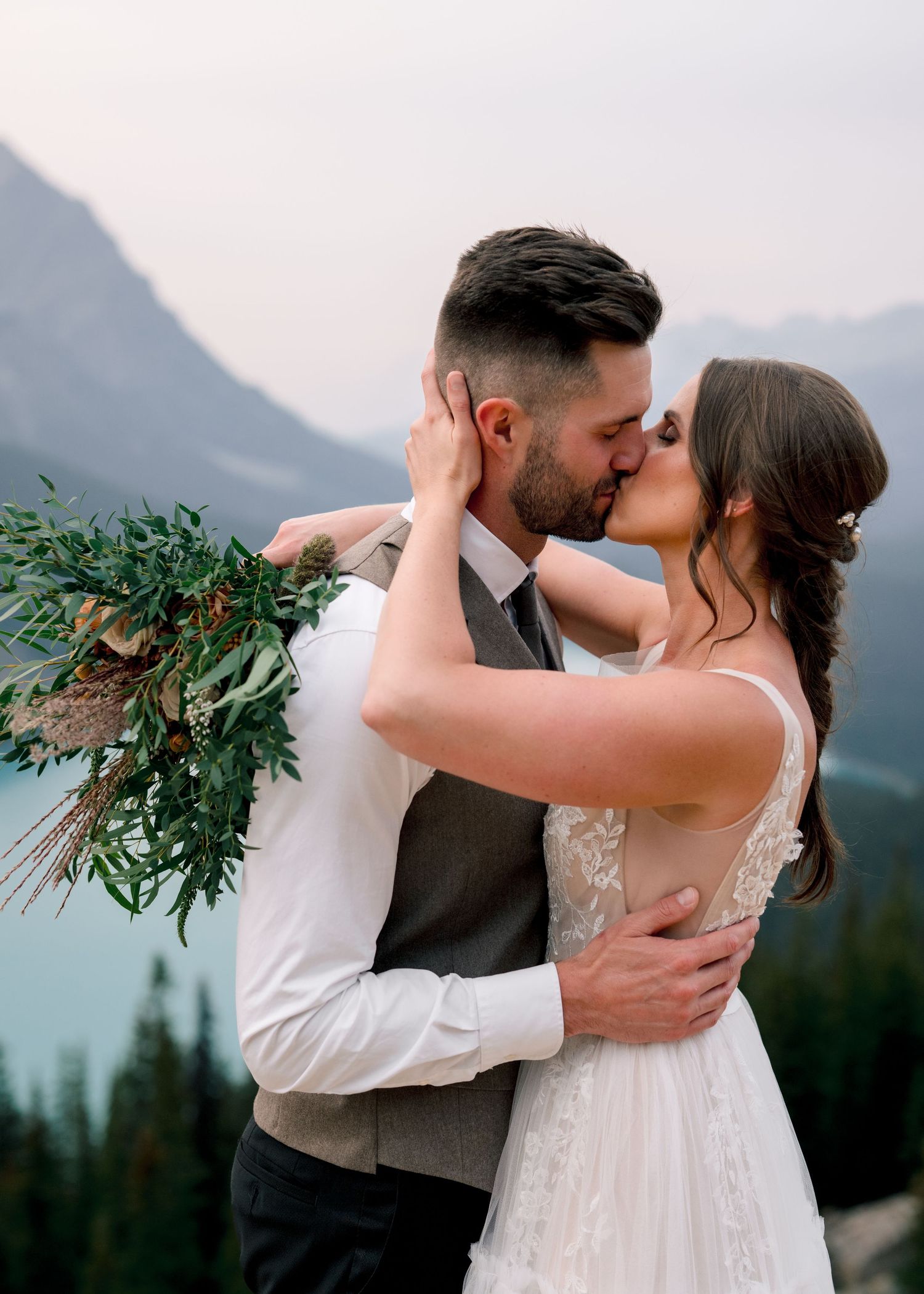 A romantic wedding photo series showing intimate moments between newlyweds against a stunning mountain backdrop.