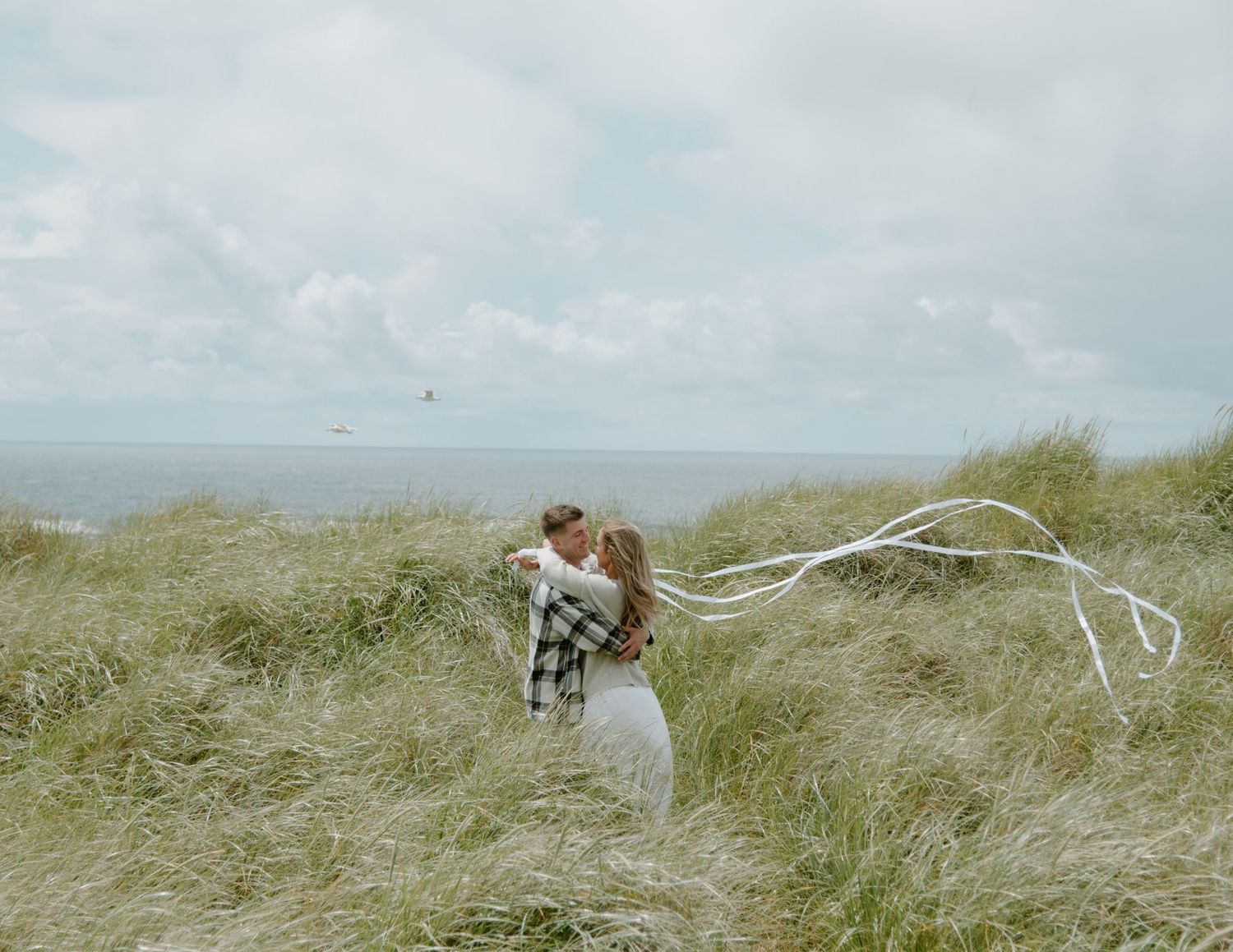 A playful coastal photoshoot with flowing fabric in the ocean breeze on Oregon Coast. Calgary Lifestyle and Engagement Photographer.