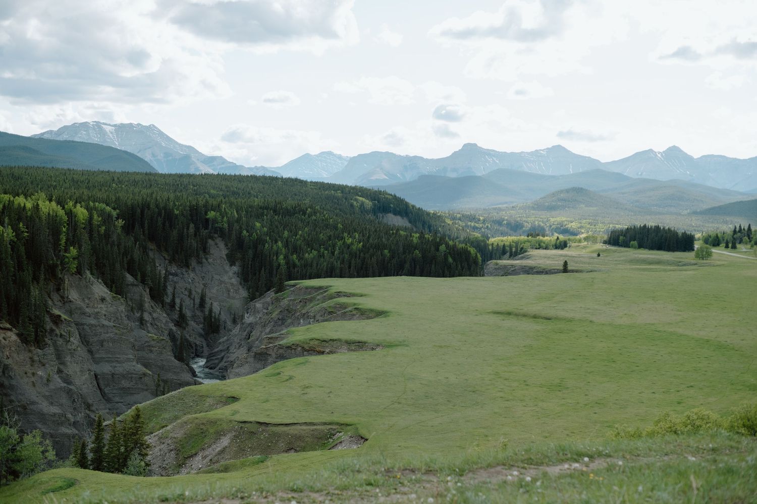 Panoramic view of rolling hills and mountain ranges in the countryside in Calgary Alberta. Calgary Lifestyle Photographer.