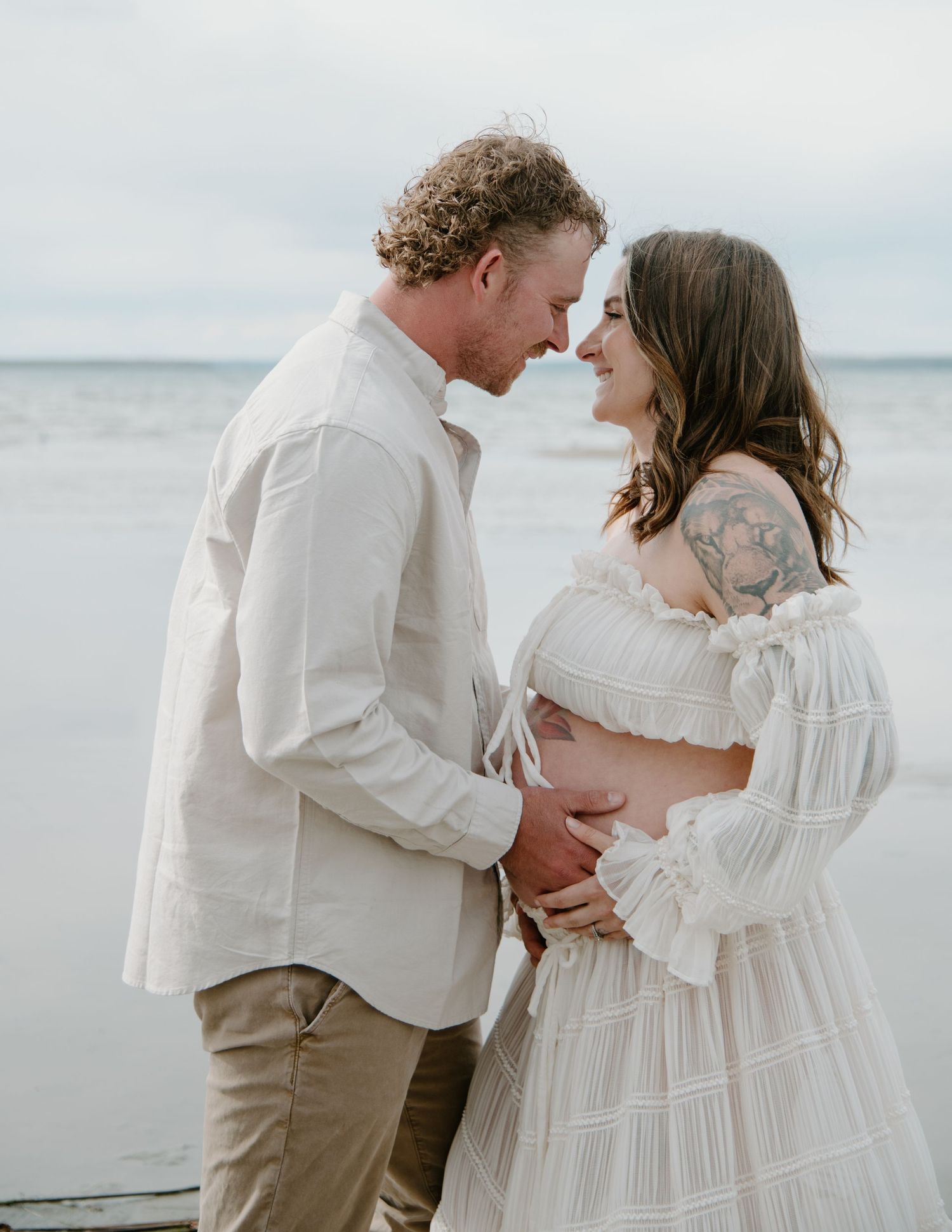 An emotional beachside portrait session with soft lighting and ocean backdrop. Calgary Alberta Maternity Photographer.