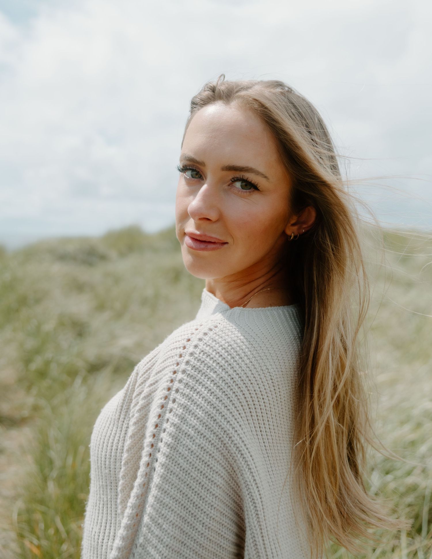 Elegant side profile portrait featuring soft natural lighting and coastal scenery in the background on Oregon Coast. Calgary Lifestyle.