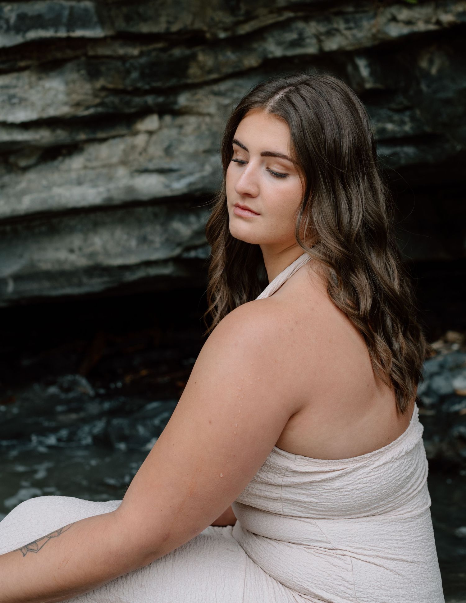 Artistic branding portrait in dress against dark rock wall background in Alberta. Calgary Branding Photographer.