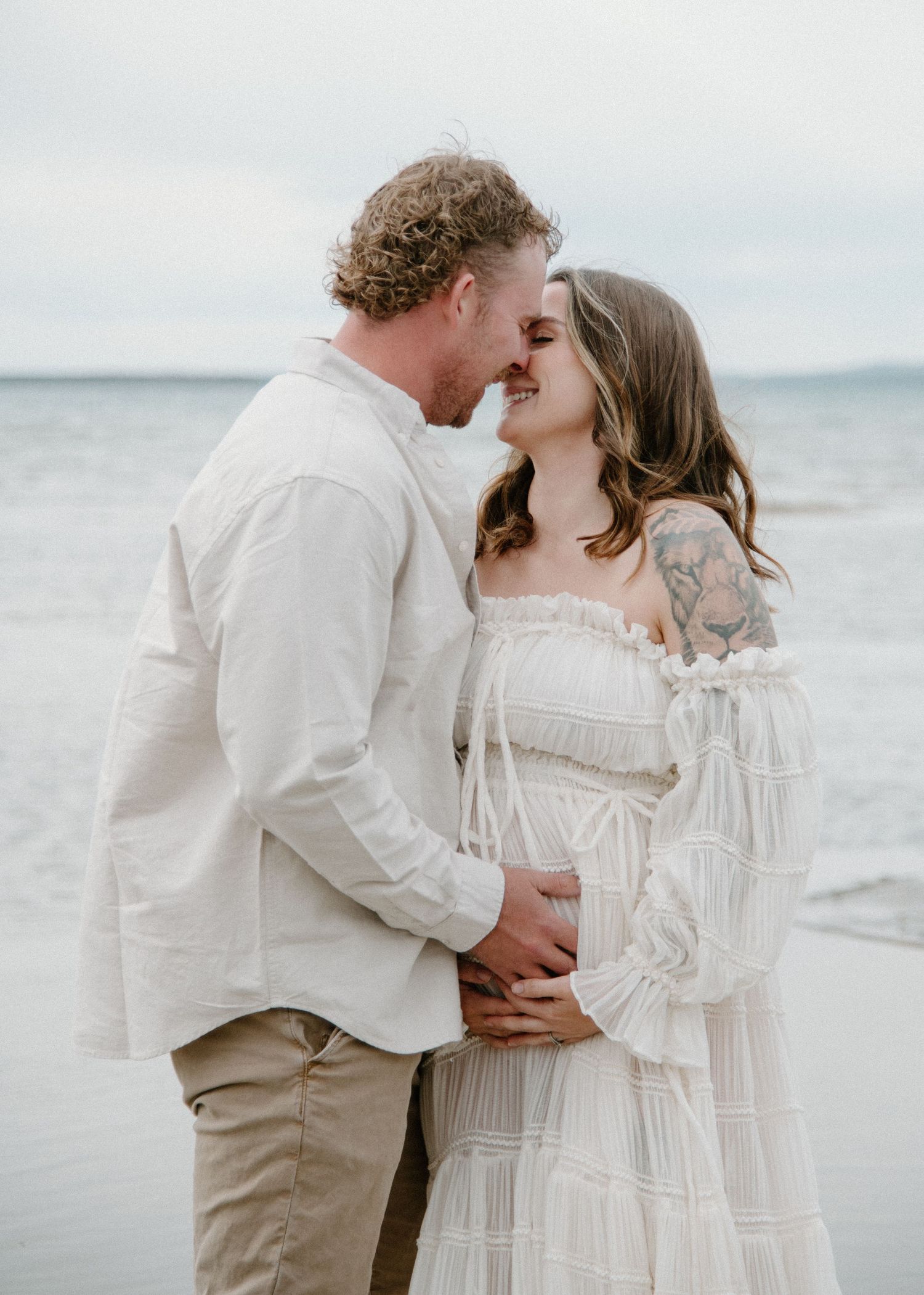 A close-up maternity photo of a couple sharing an intimate moment on a beach. Calgary Alberta Maternity Photographer.