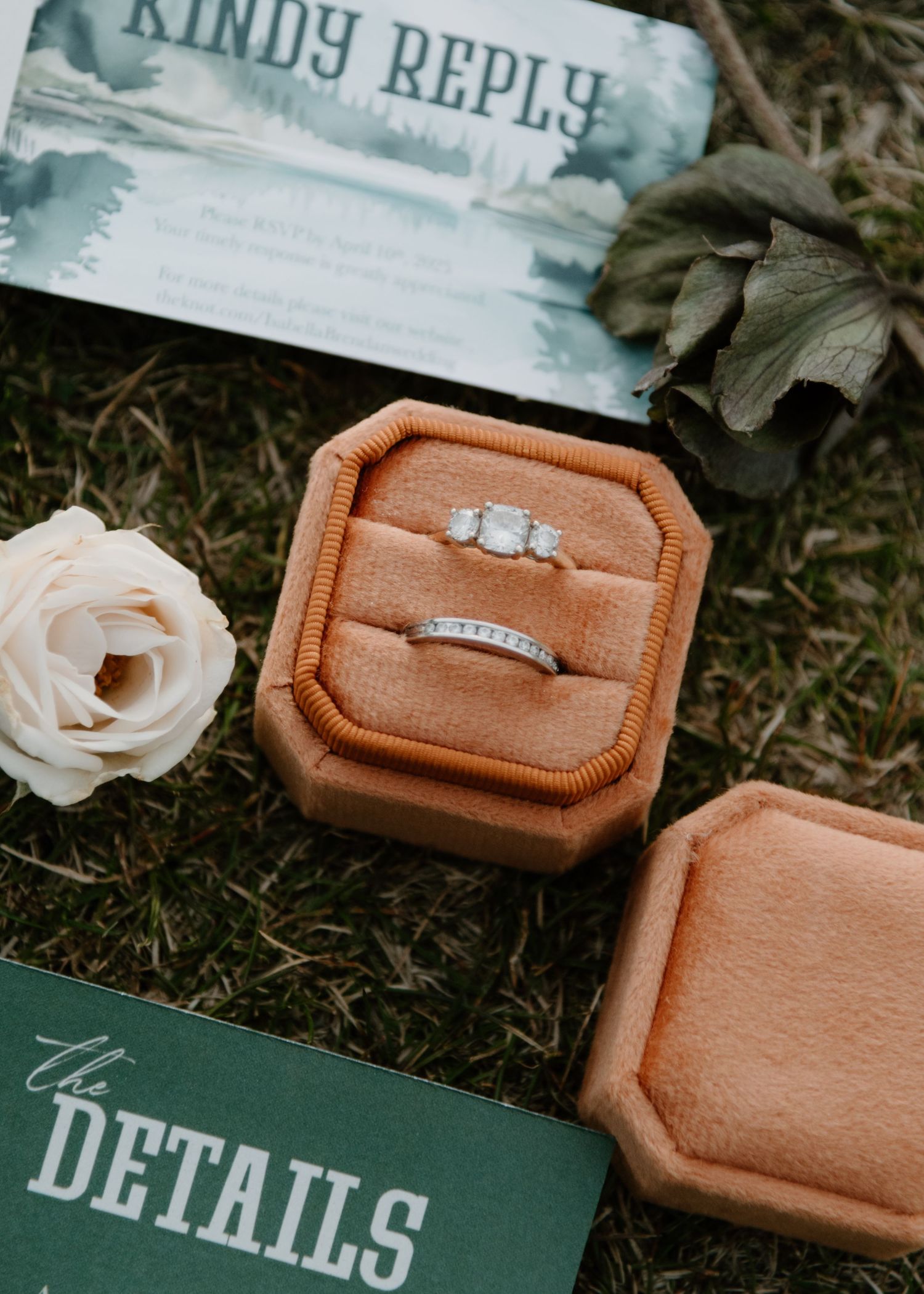 Close-up of wedding stationery details with tan ring boxes and teal paper designs. Calgary Wedding Photographer