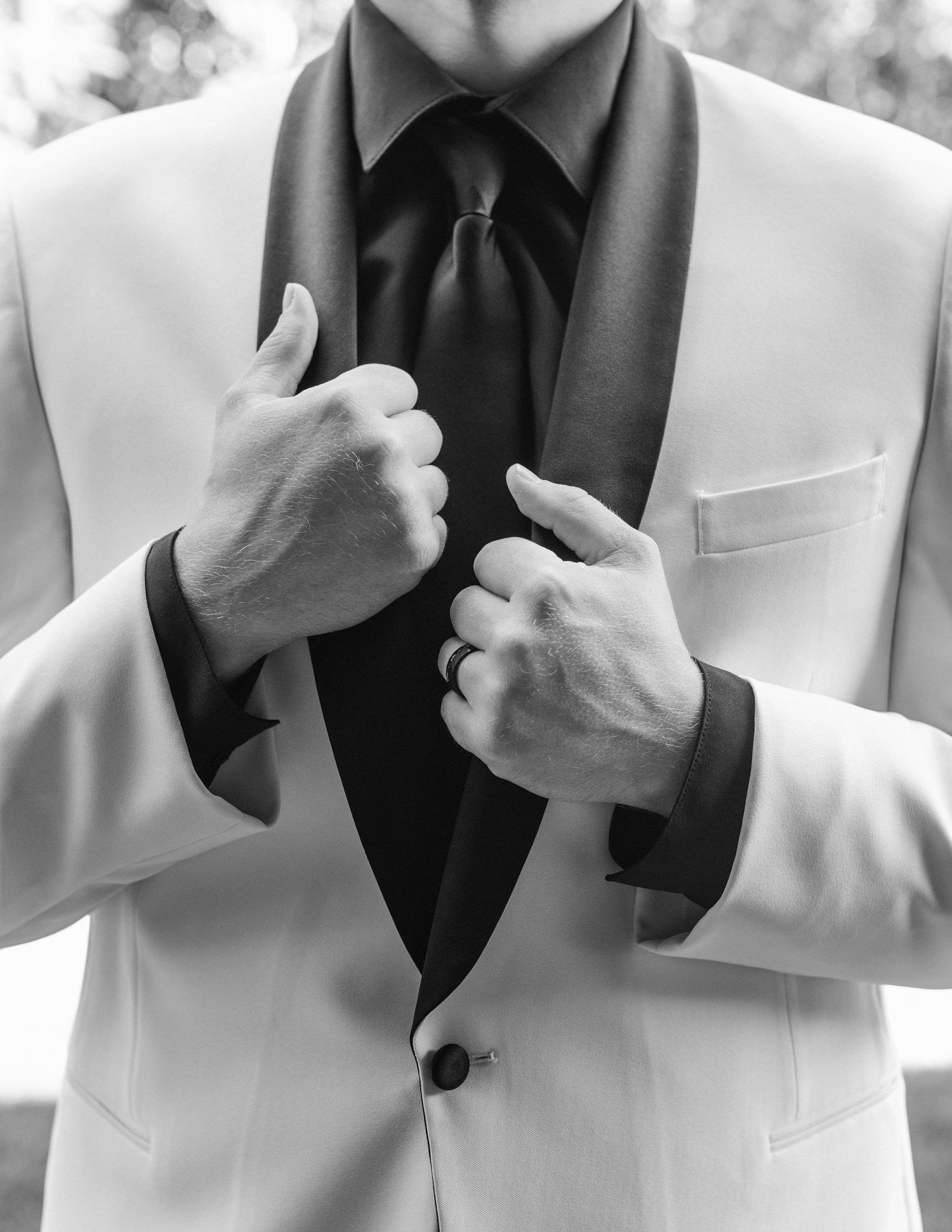 Men in black dress shirts and white tuxedo jackets strike dramatic poses against a monochrome background.