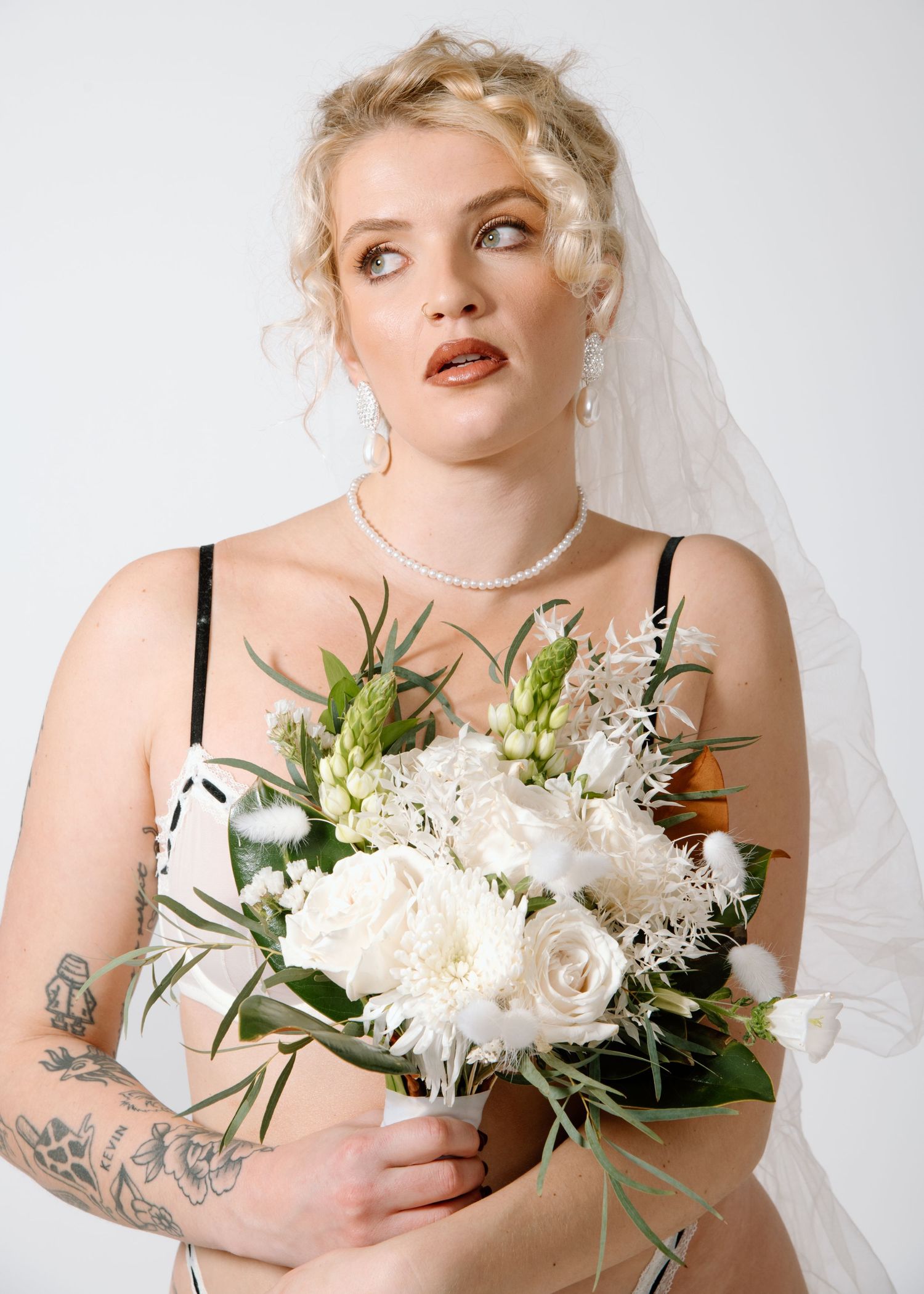 Studio bridal portrait with white bouquet featuring pearl necklace and veil Calgary Bridal Boudoir Photographer