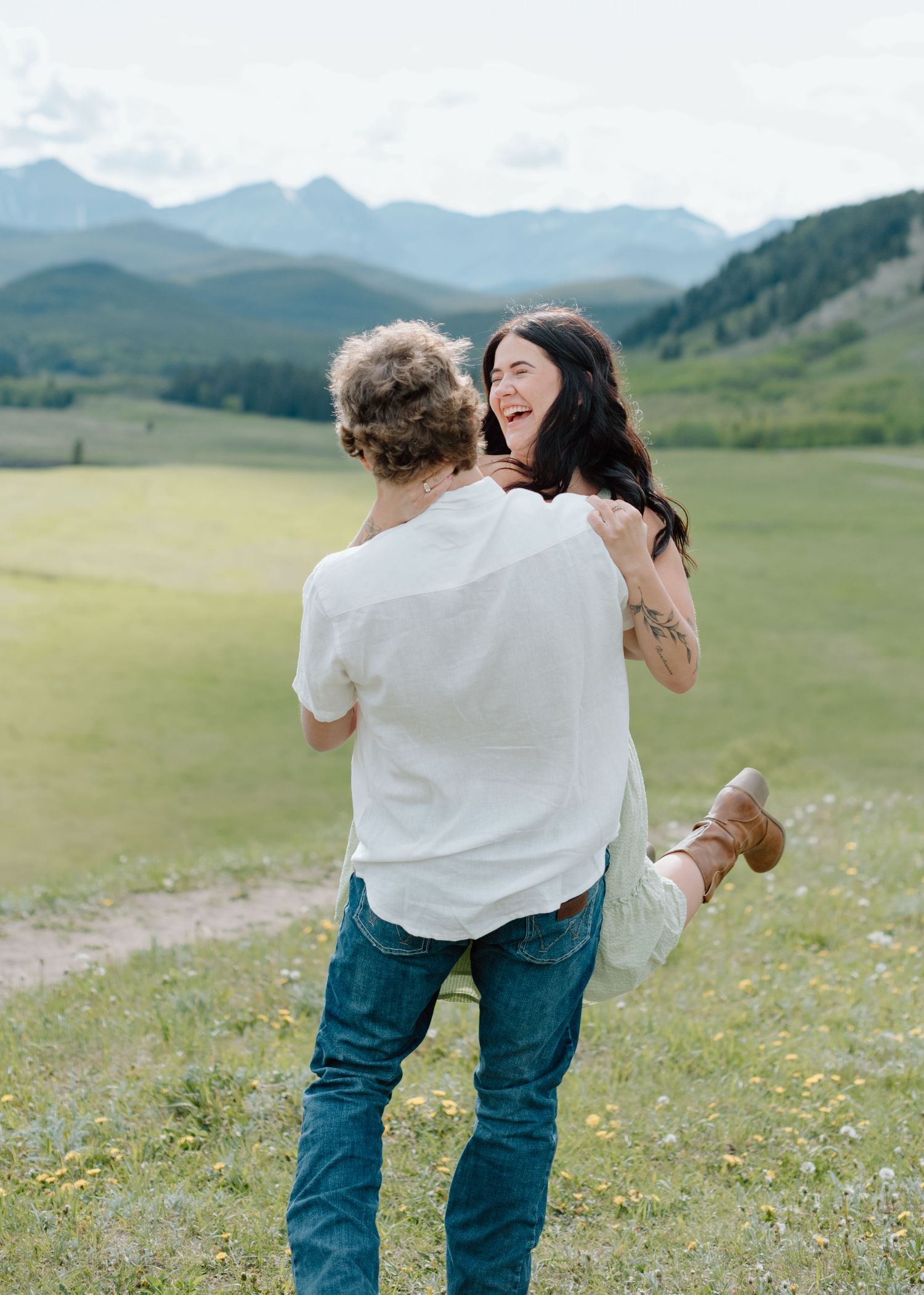 A playful moment captured between two people in a mountain meadow setting in Calgary, Alberta Calgary Lifestyle and Engagement Photographer