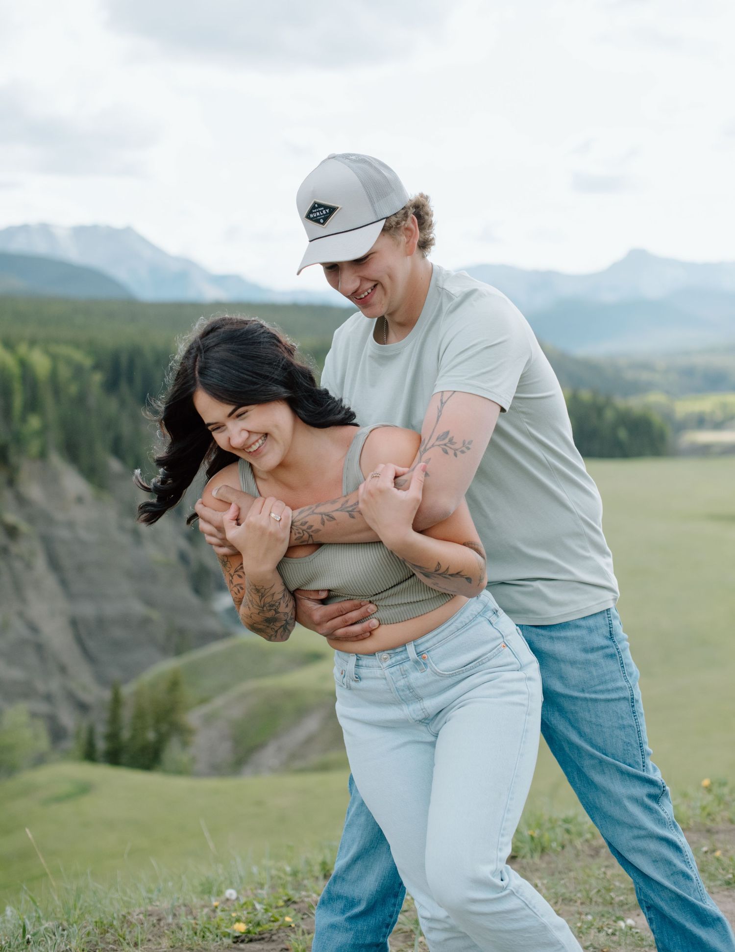 A couple sharing a romantic moment in a mountain meadow with scenic views. Calgary Alberta Engagement Photographer.