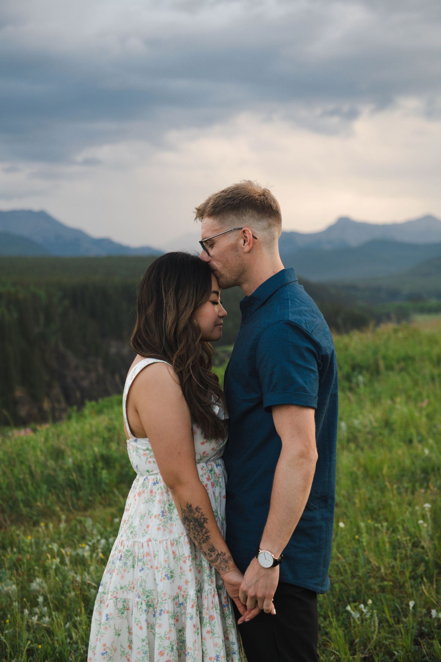 A romantic moment between a couple in a mountain meadow during sunset in Calgary. Calgary Lifestyle and Engagement Photographer.