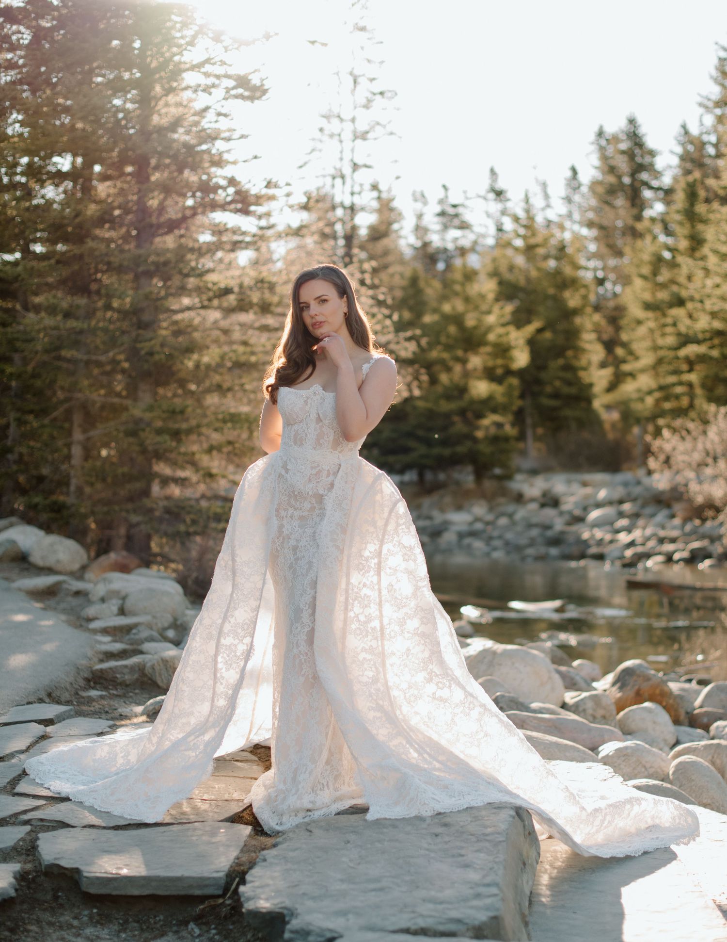 Ethereal bridal portraits featuring flowing lace dress in forest setting at golden hour at Lake Louise Banff andCalgary Wedding Photographer