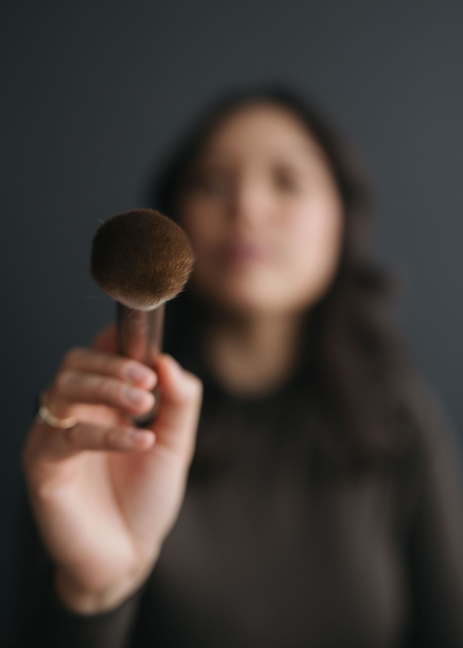 A hand holds up a chocolate truffle against a dark background in a sequence of artistic food photography shots.