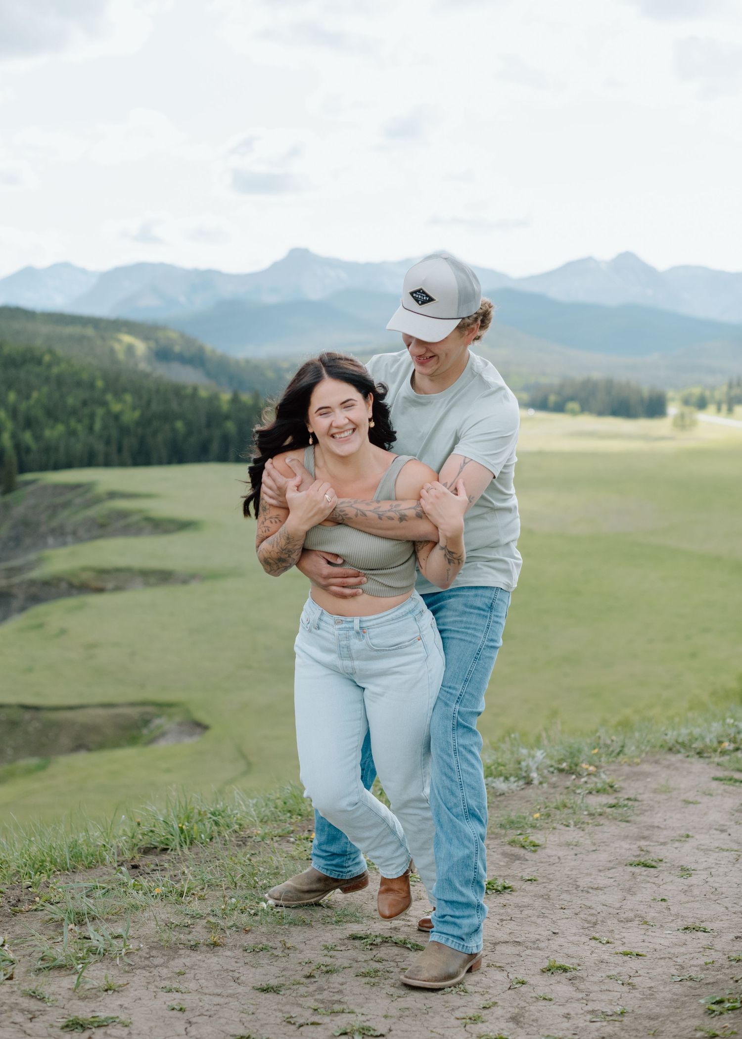 A couple dancing and laughing together on a mountain overlook. Calgary Alberta Engagement Photographer.
