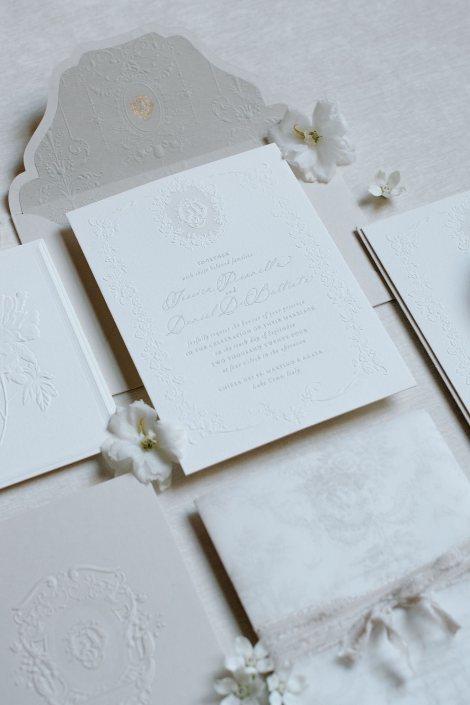 Elegant white wedding invitation suite with embossed details and small white flowers as decoration at the Brownstone YYC. Calgary Wedding