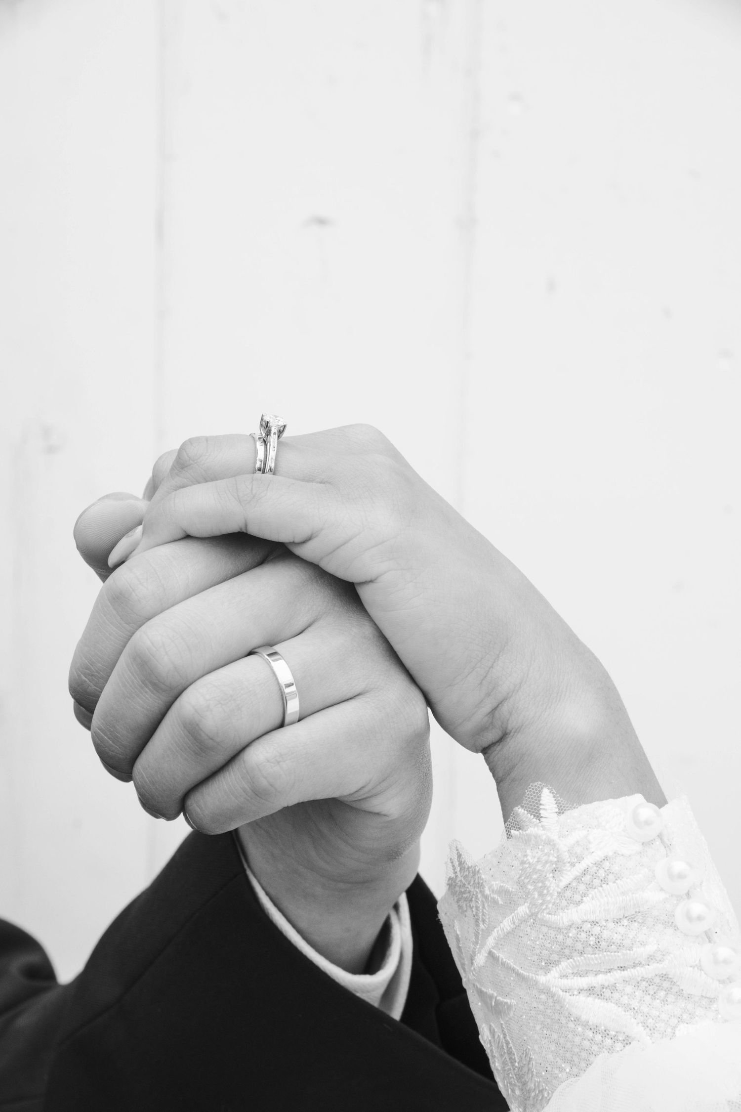 Black and white close-up of newlyweds' hands showing their wedding rings. Calgary Wedding Photographer