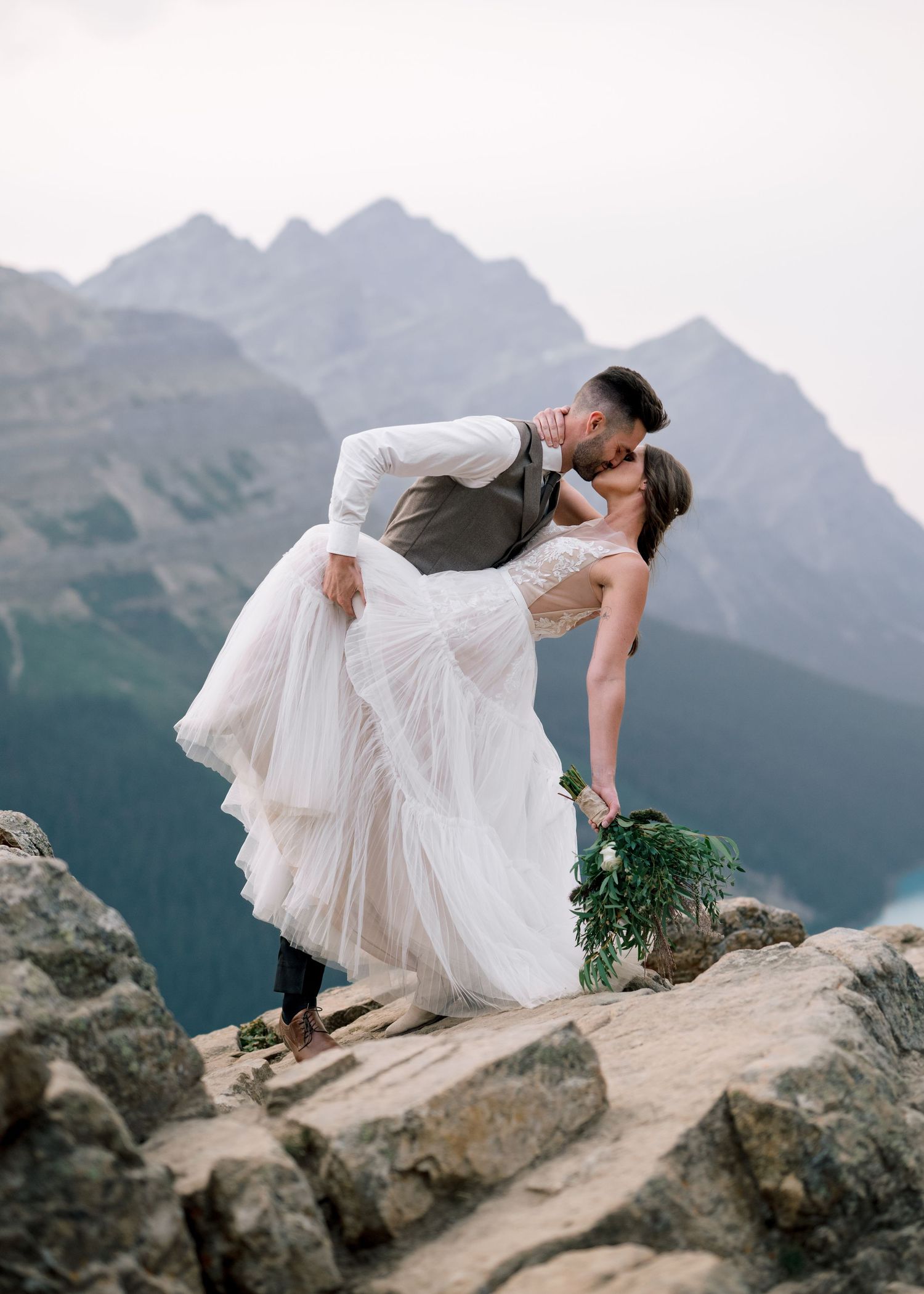Ethereal wedding dress flowing in the wind against dramatic mountain peaks in a series of artistic silhouette poses.