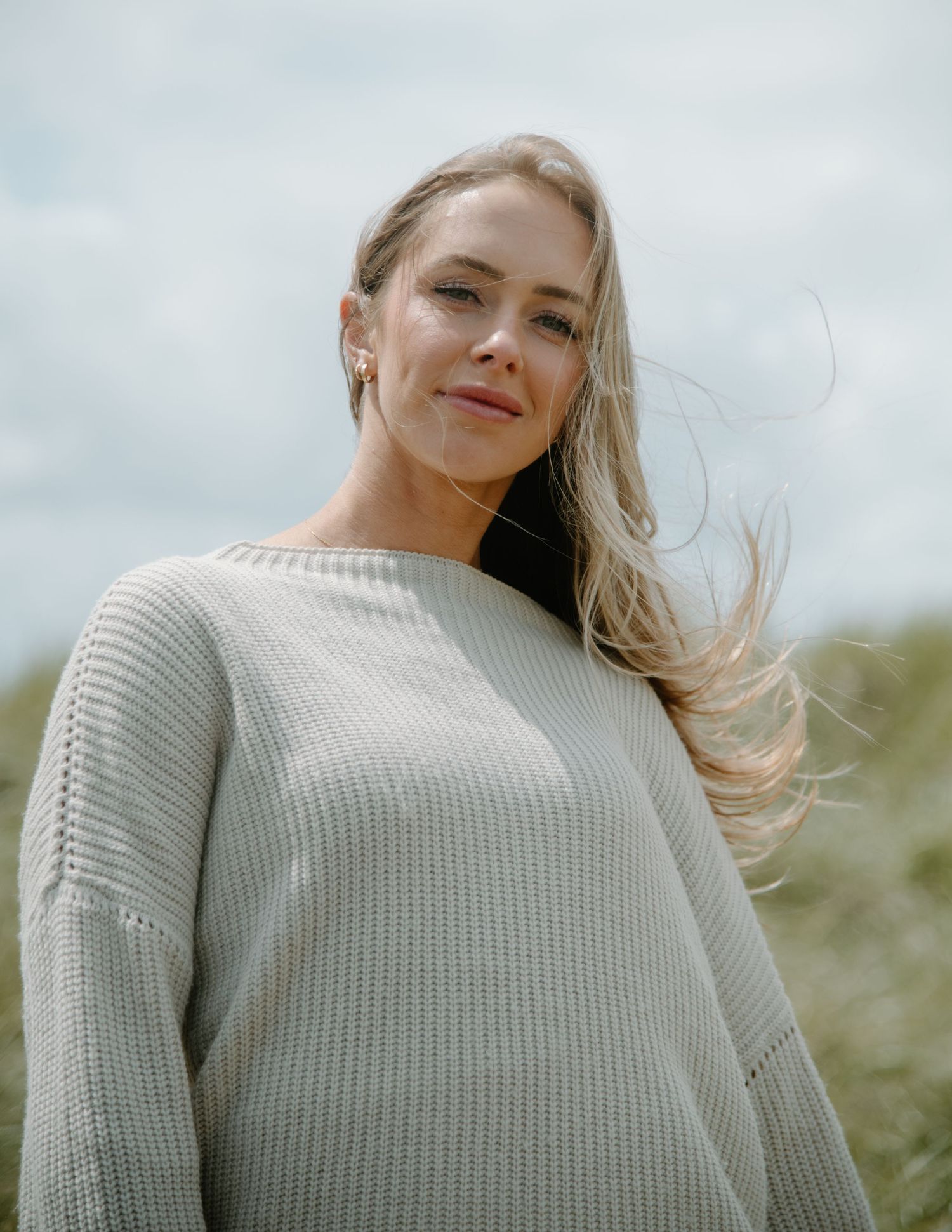 Natural lifestyle portrait shot of a person wearing a light gray knit sweater in an outdoor setting on Oregon Coast. Calgary Photographer.