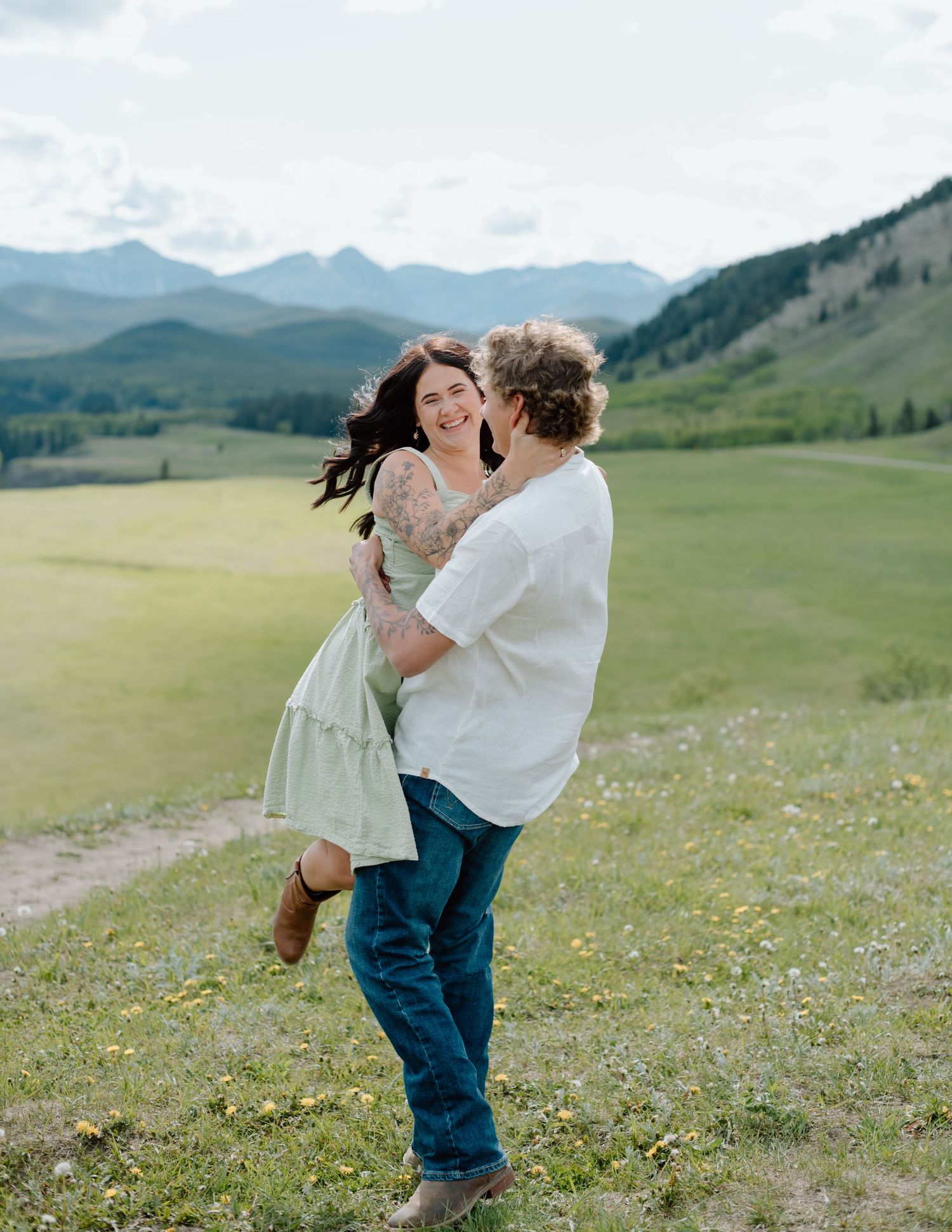 A joyful moment captured between two people against a backdrop of mountain vistas in Calgary, Alberta Calgary Lifestyle and Engagement Photo