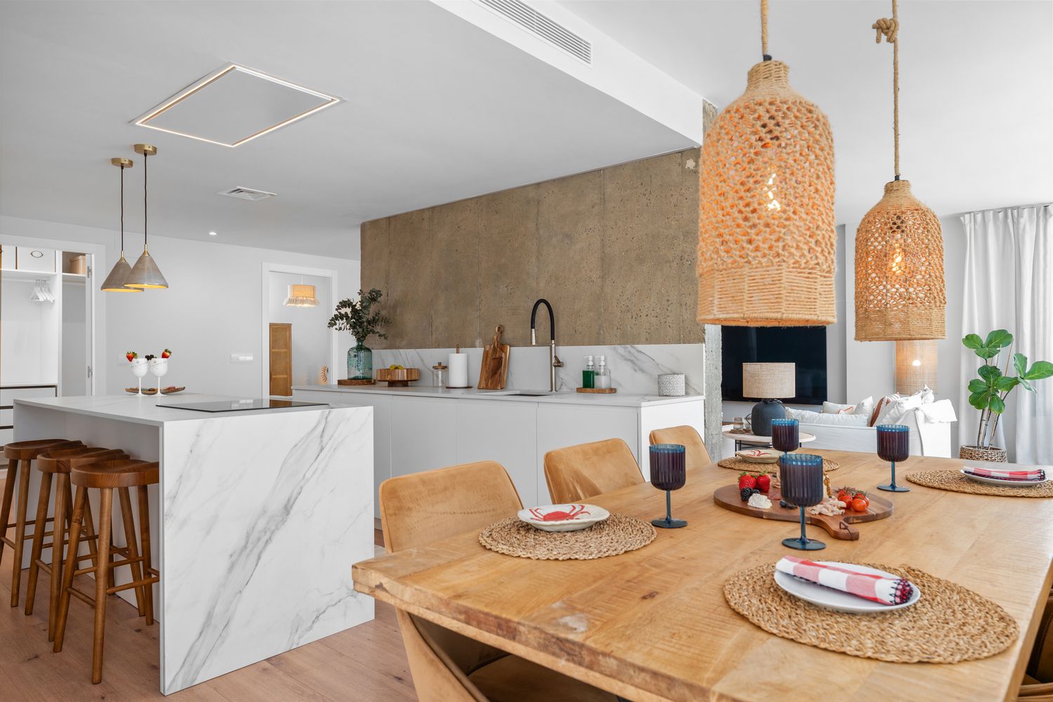 Modern open-plan kitchen and dining area in Costa Blanca. Real estate photography with warm Mediterranean details and styled wood accents.