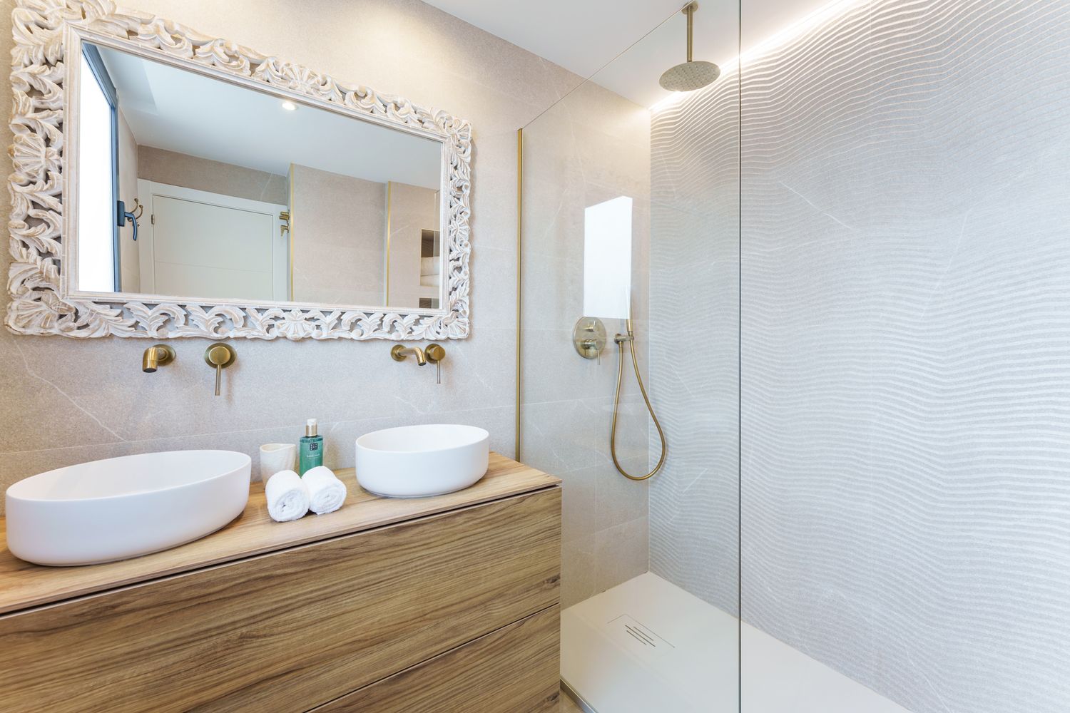 Warm-toned bathroom interior in Alicante with double sinks and mosaic mirror. Captured for a real estate and interior design listing.